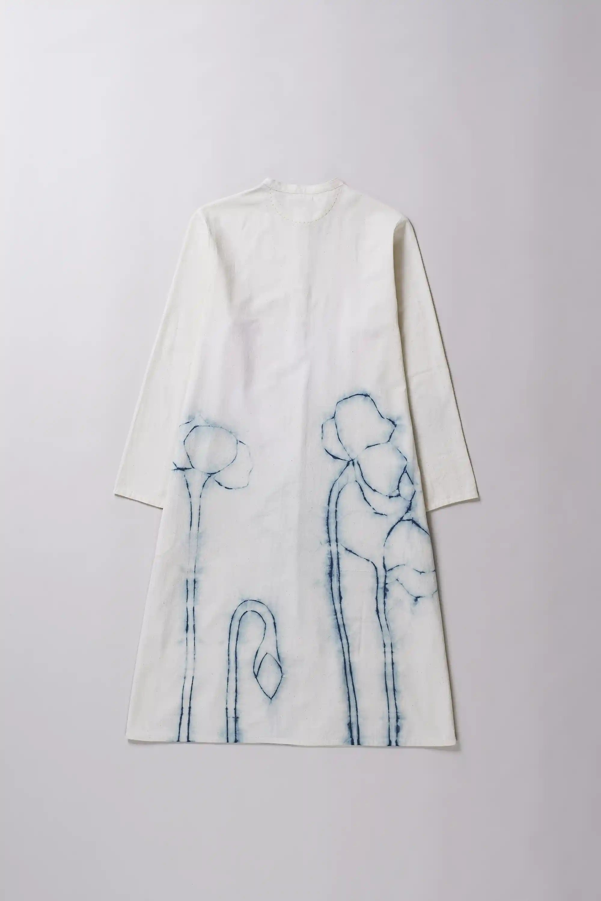 Back image of ecru dress with a indigo shibori detail on a grey background