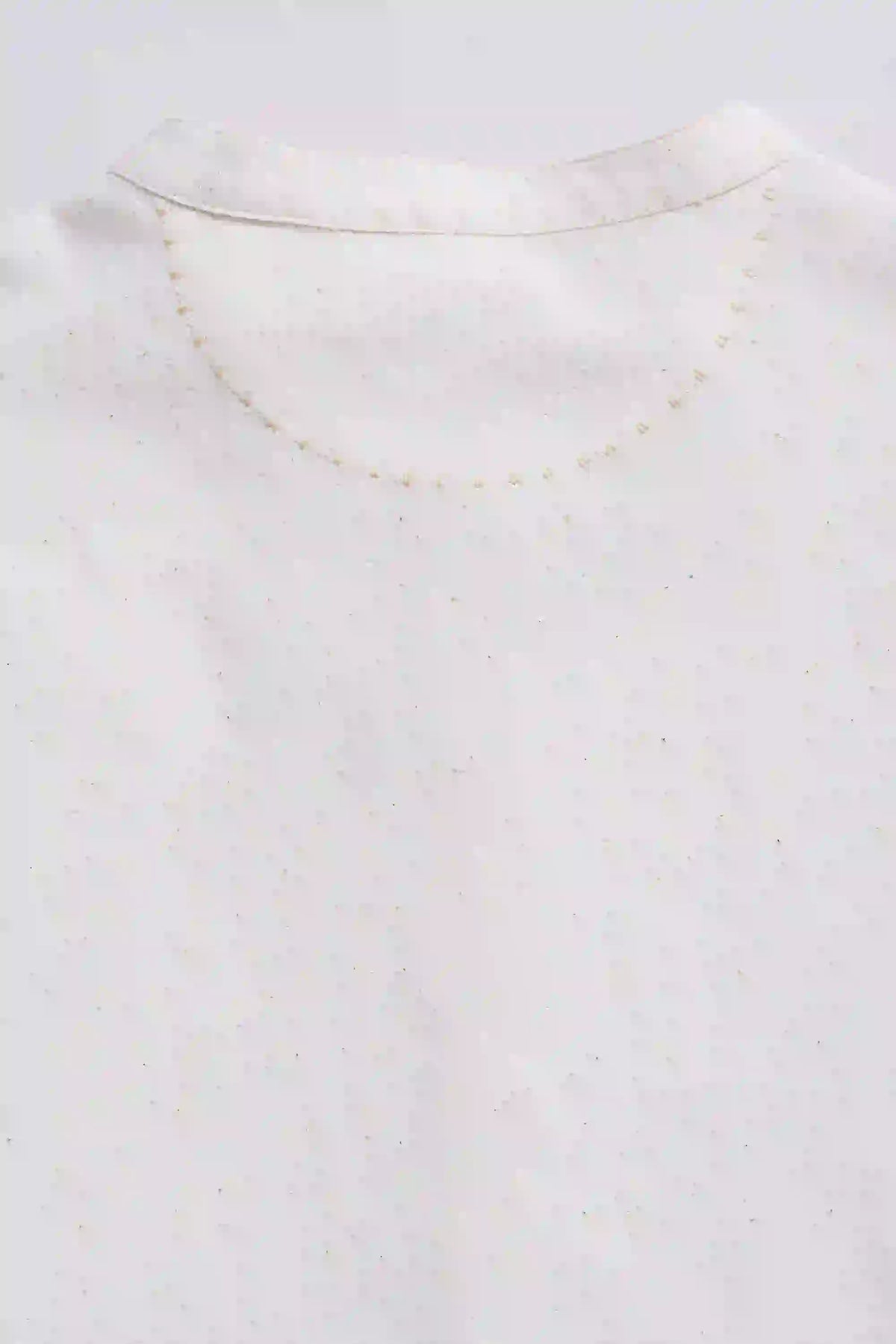 Close-up of a gold necklace on a white background