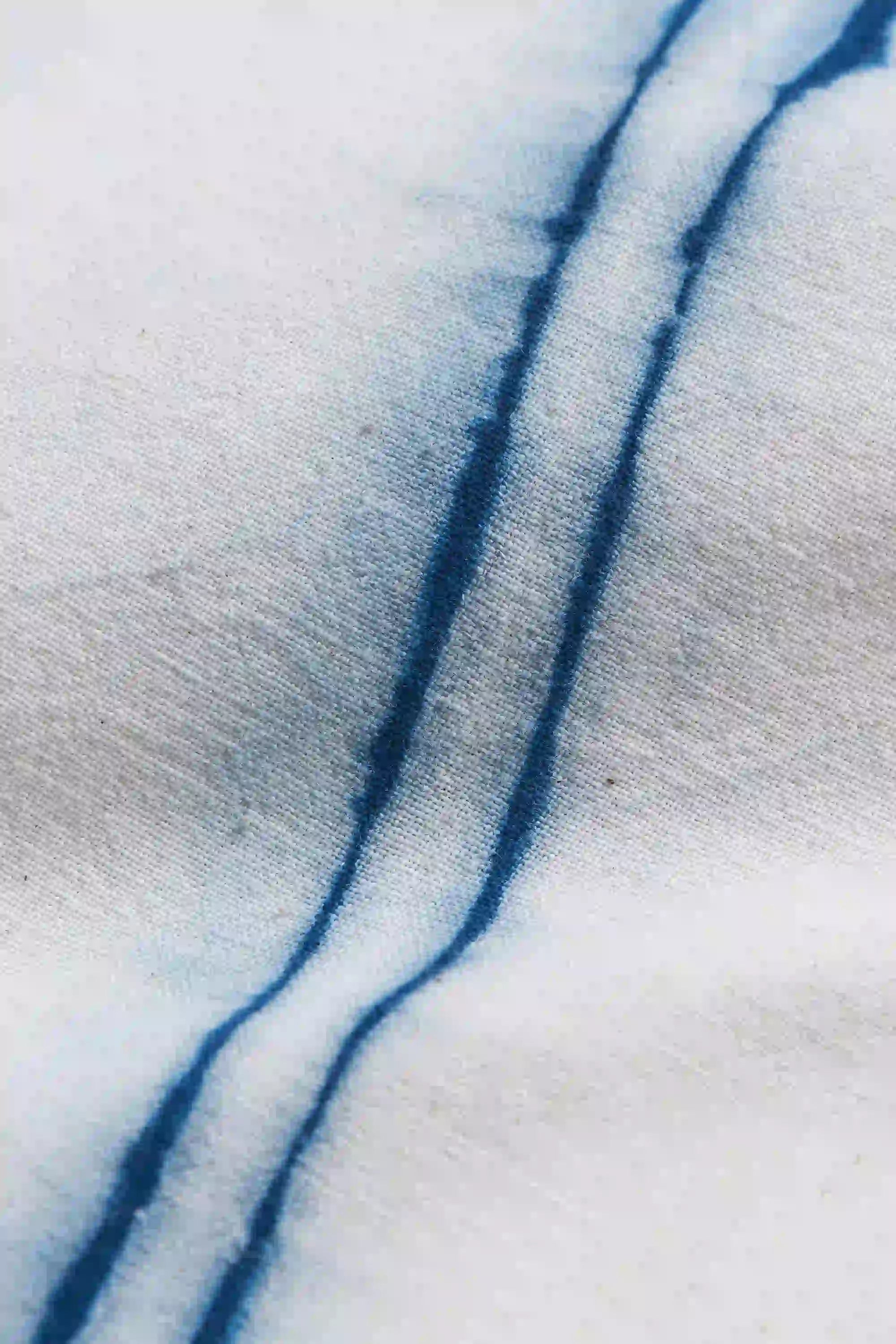 Close-up of indigo shibori on a ecru fabric