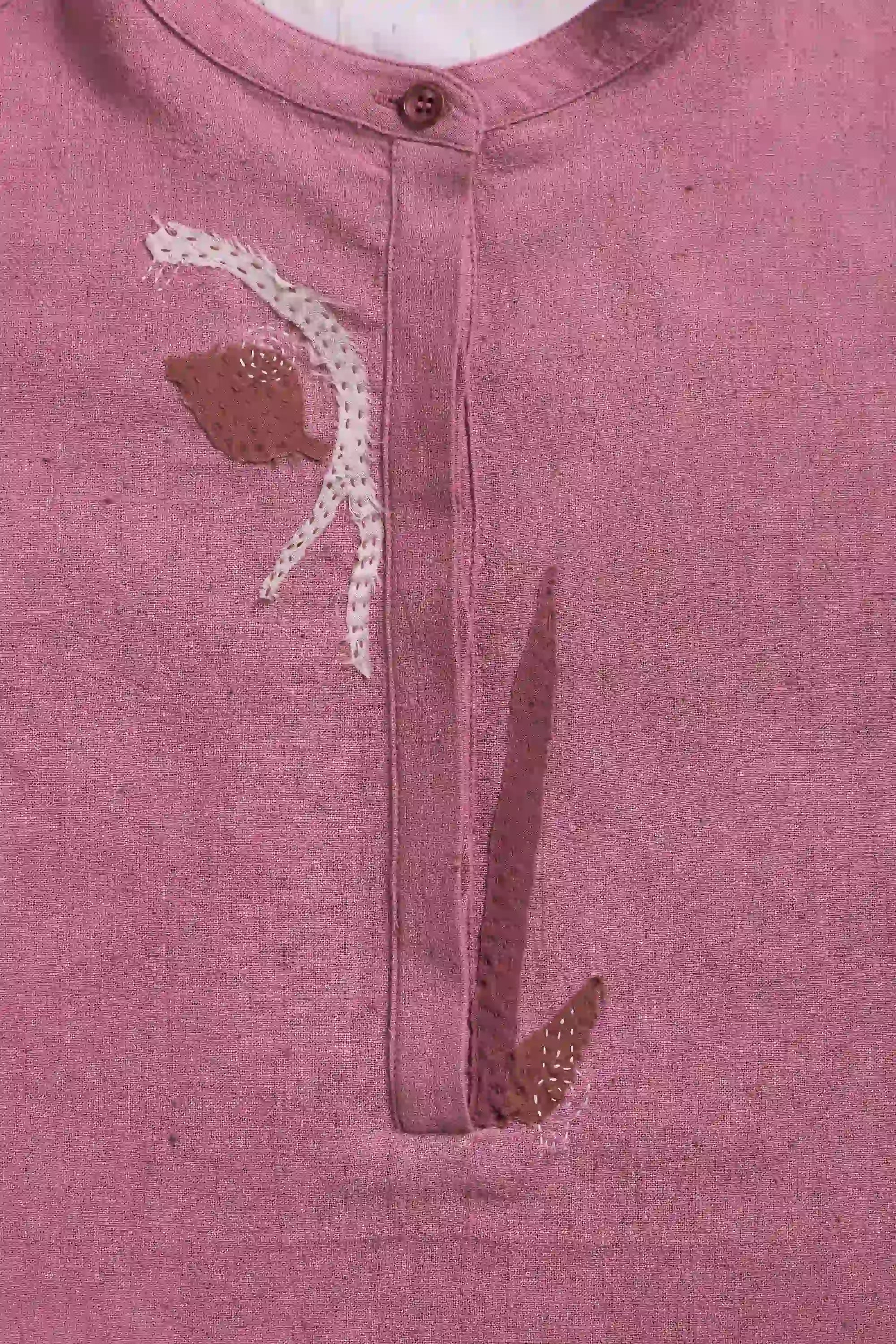 Close-up of a pink garment with floral embroidery