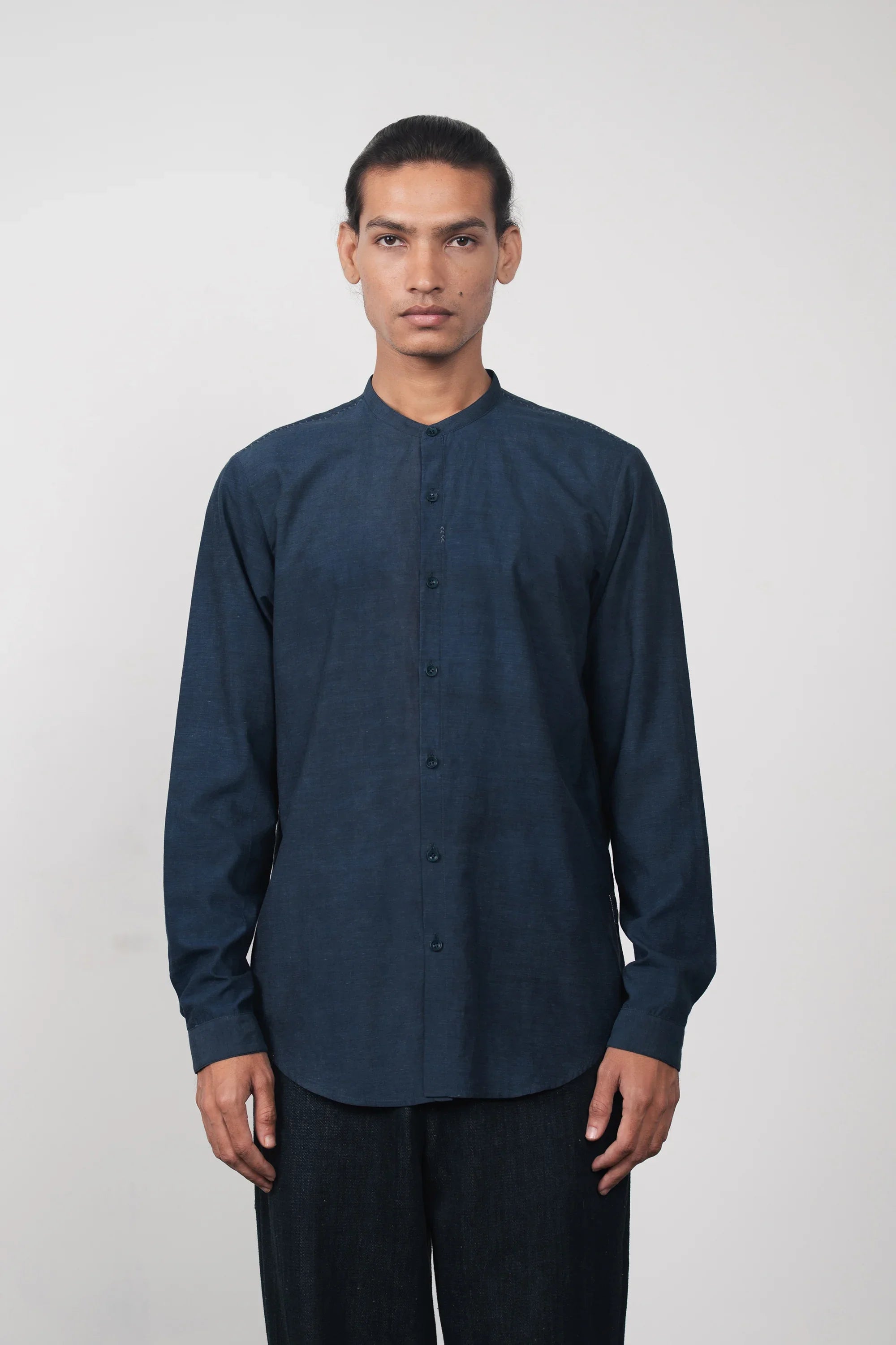 A man wearing estate blue shirt