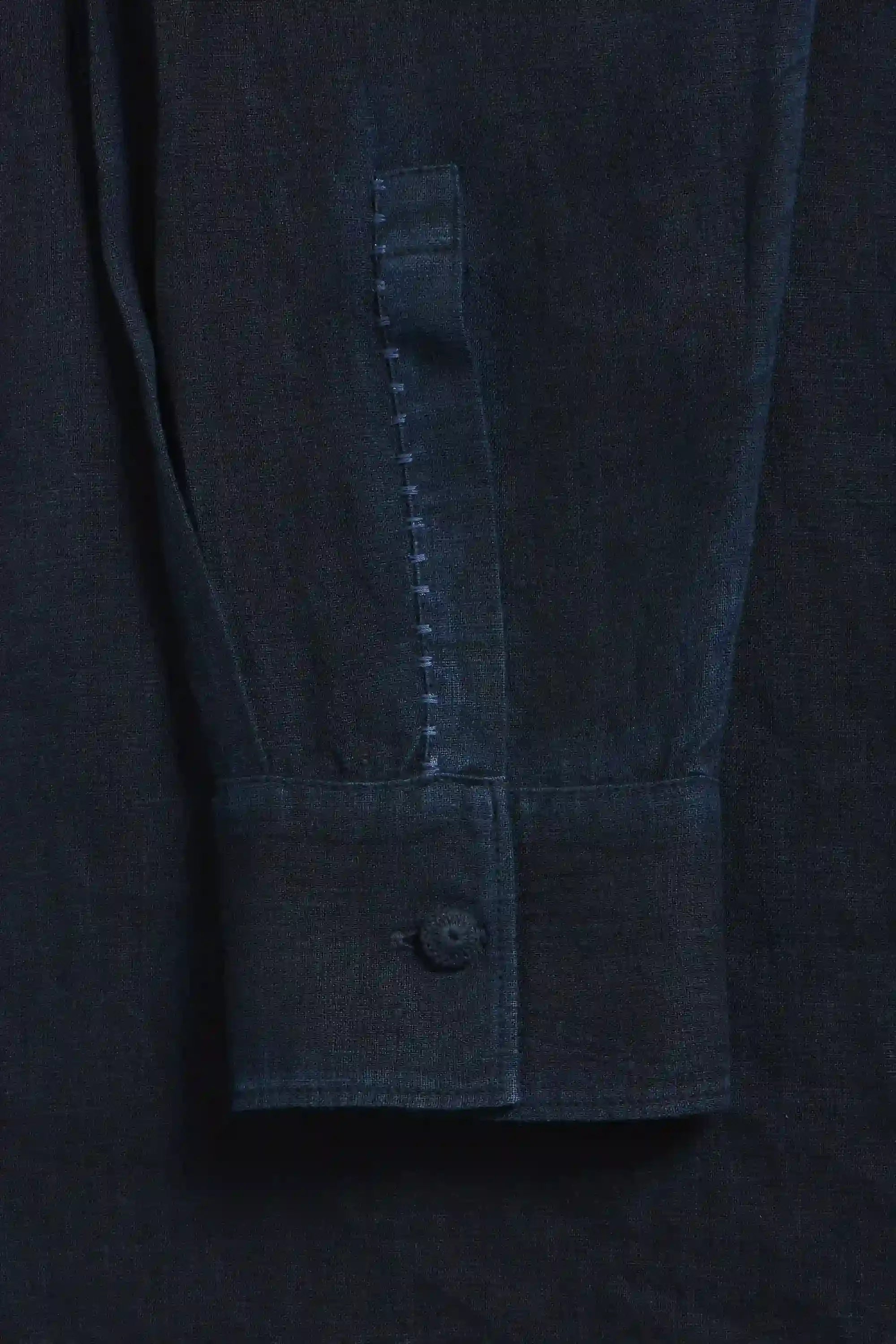 Close-up of a black shirt with a button