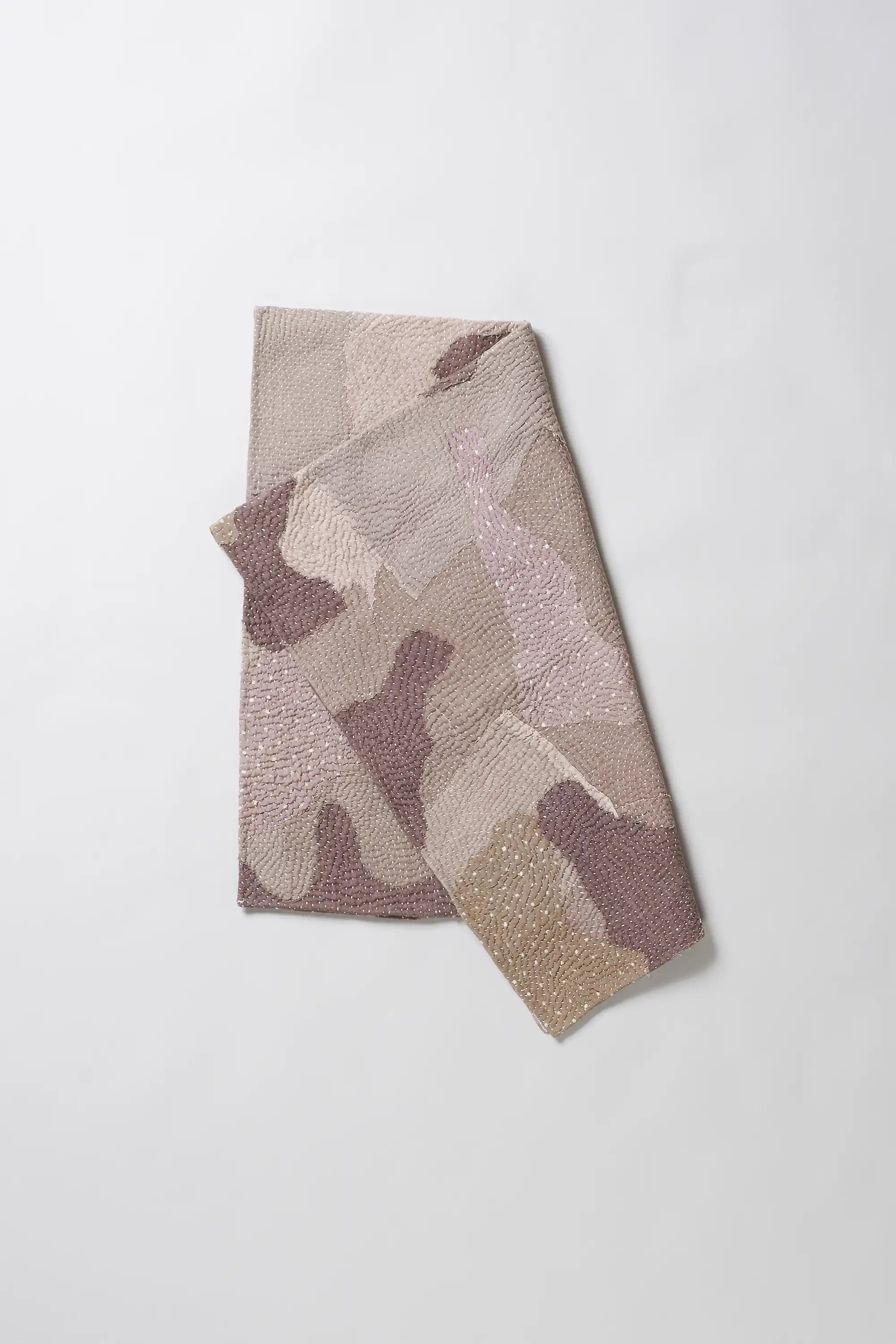 Folded quilt with patchwork in shades of wine