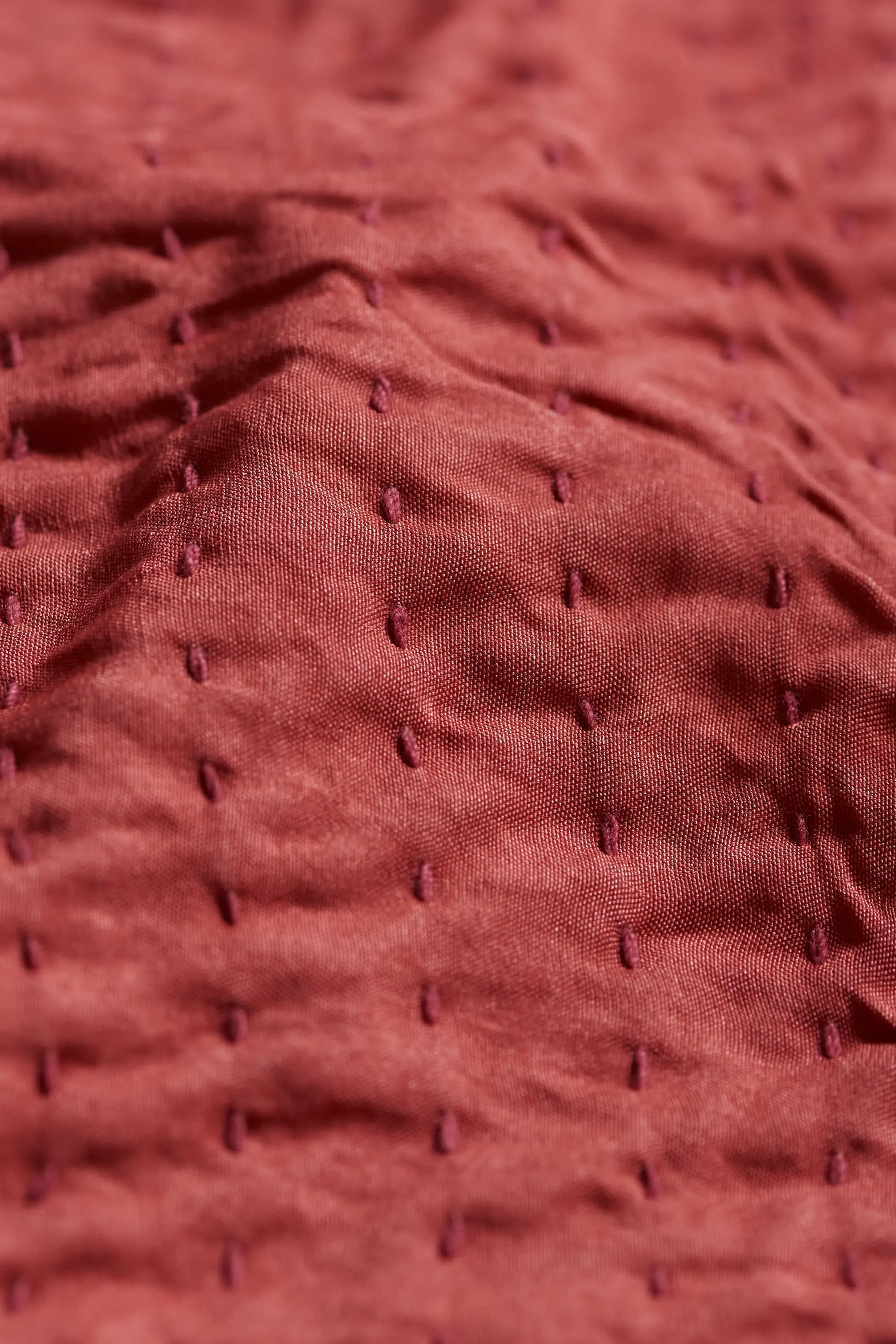 Close-up of red quilt with kantha work