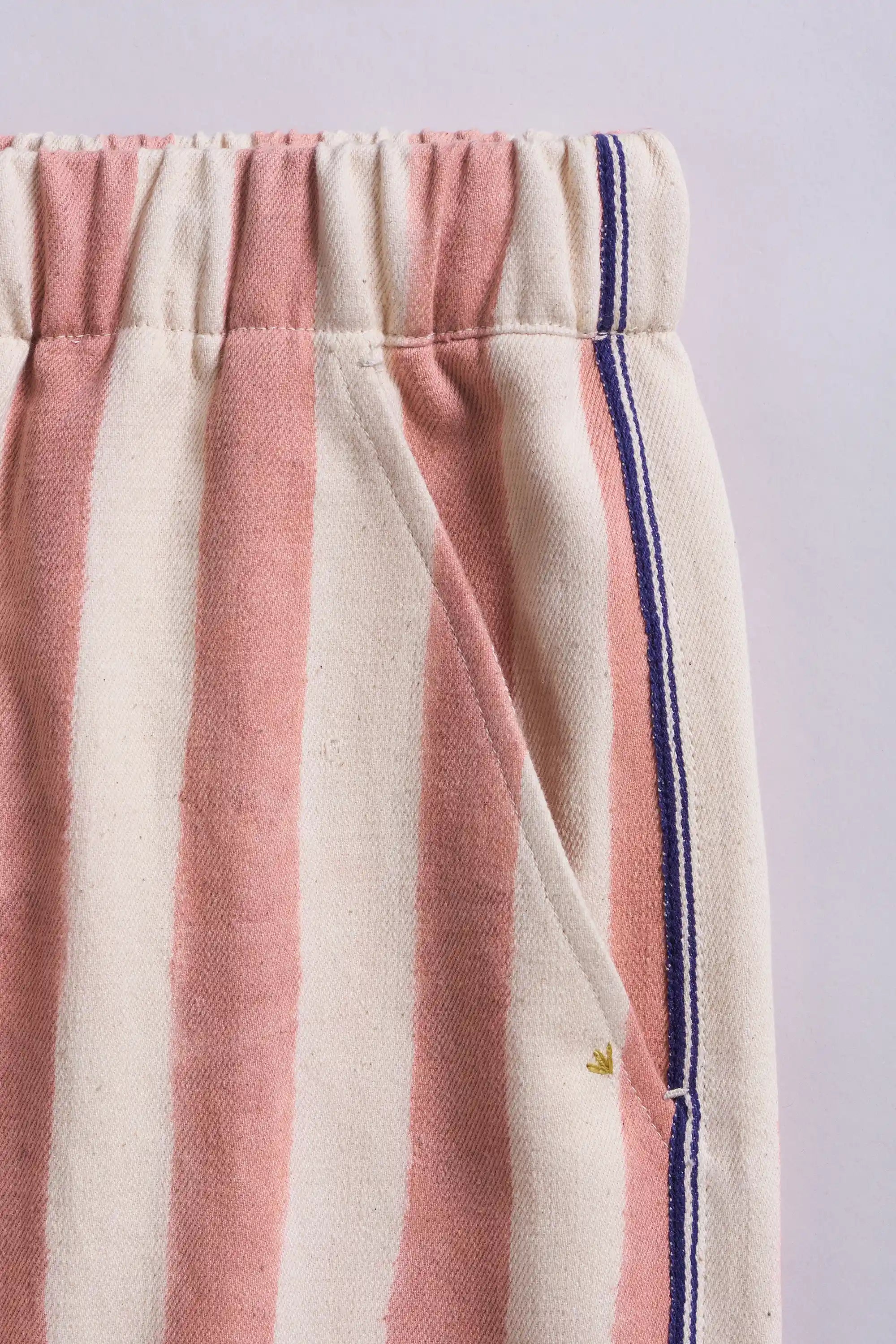 Close-up of striped pants with pink and white pattern with pocket on a light grey background