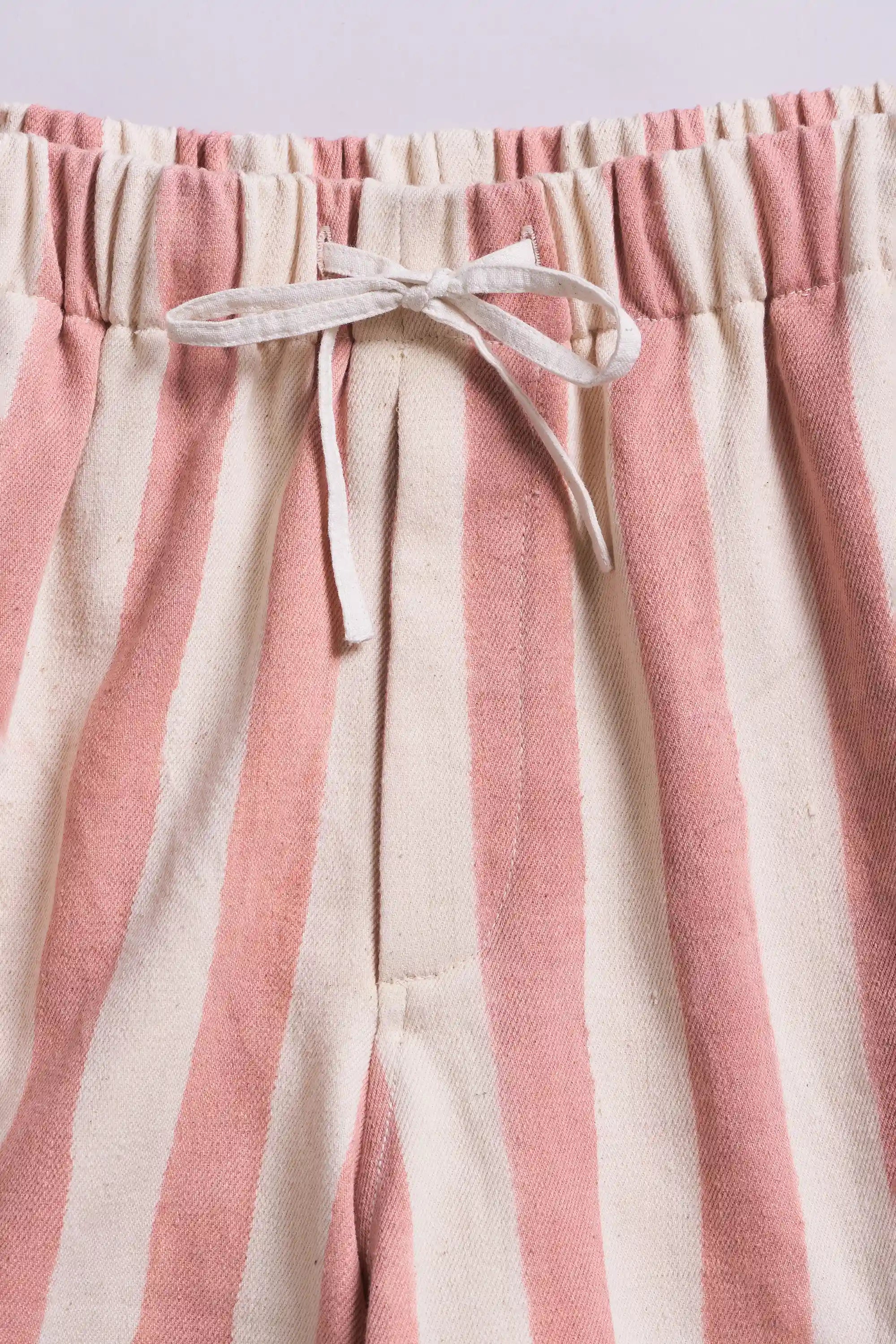 Close-up of pink and beige striped pants with a drawstring waistband.