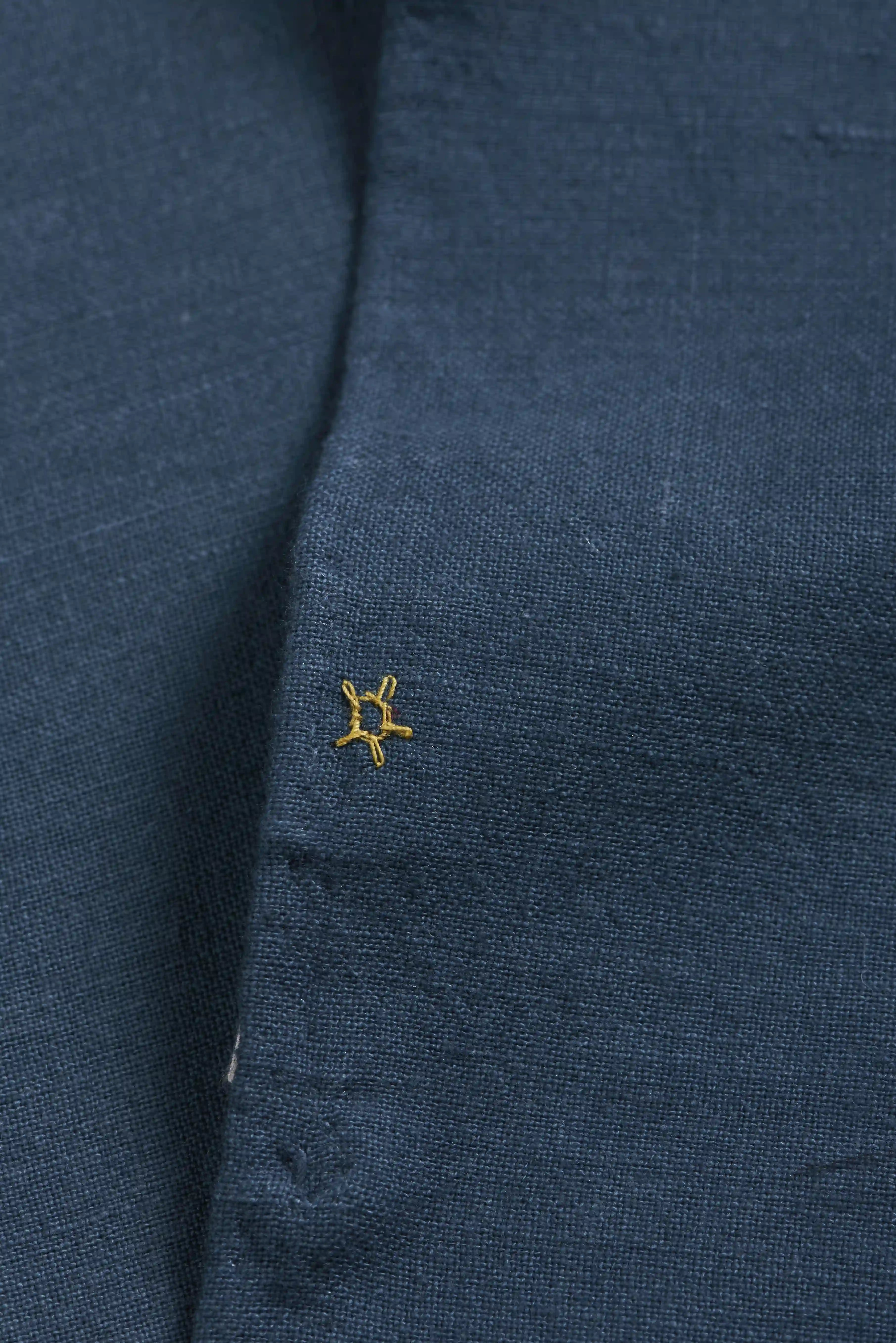 Close-up of a blue fabric with a gold small pehchan 