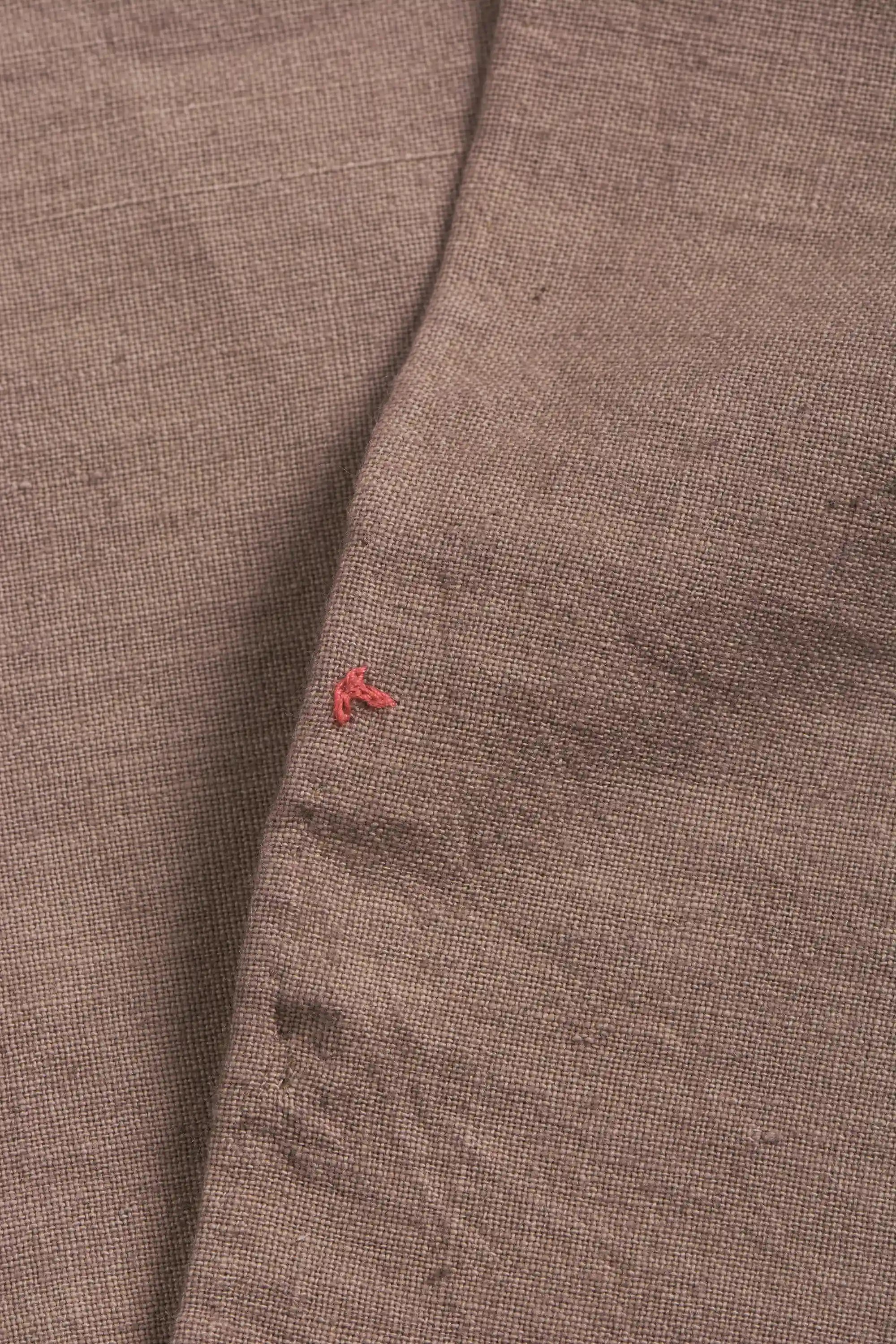 Close-up of brown fabric with a small red pehchan 