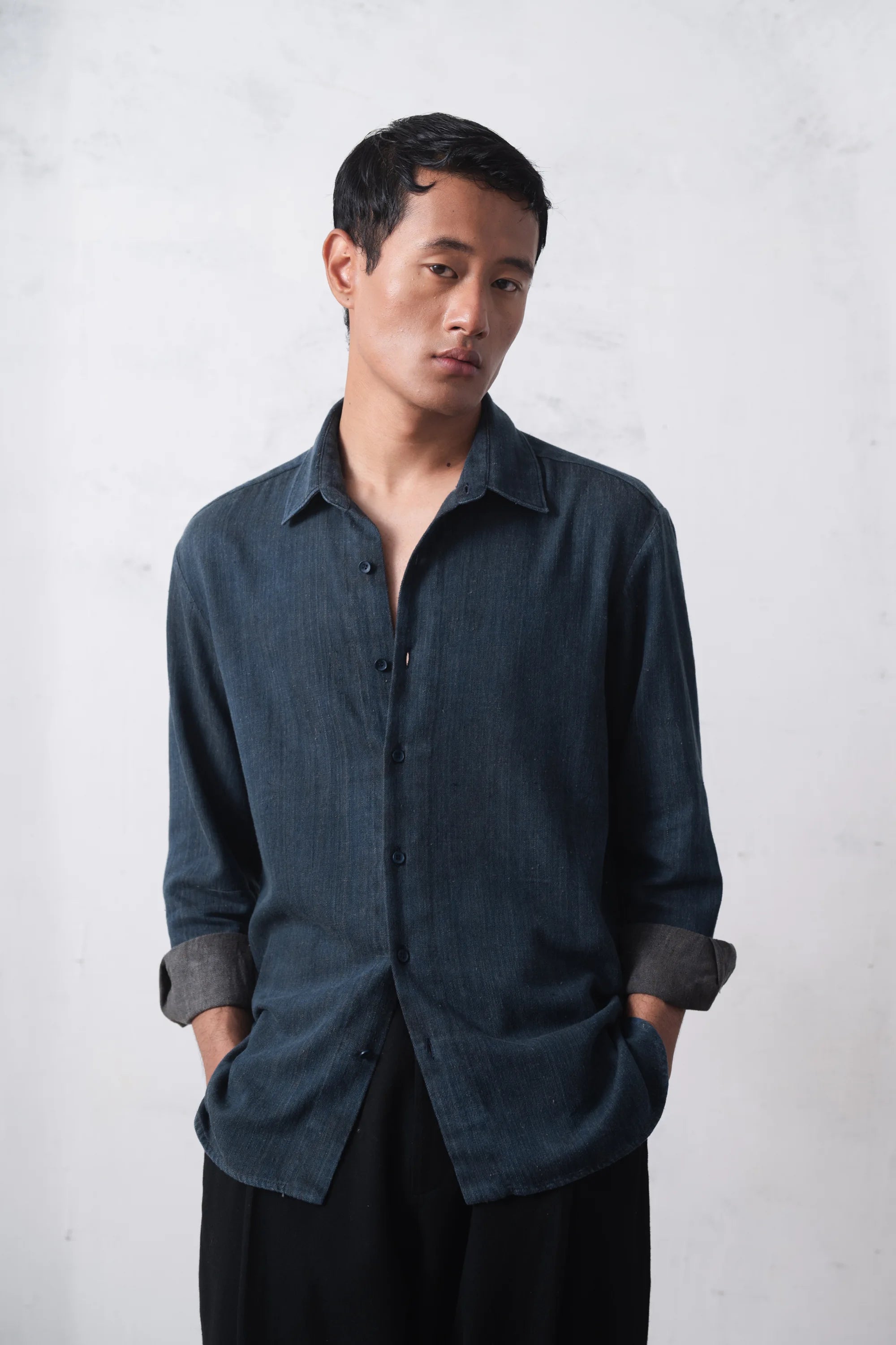 Man wearing a indigo shirt on a light grey background