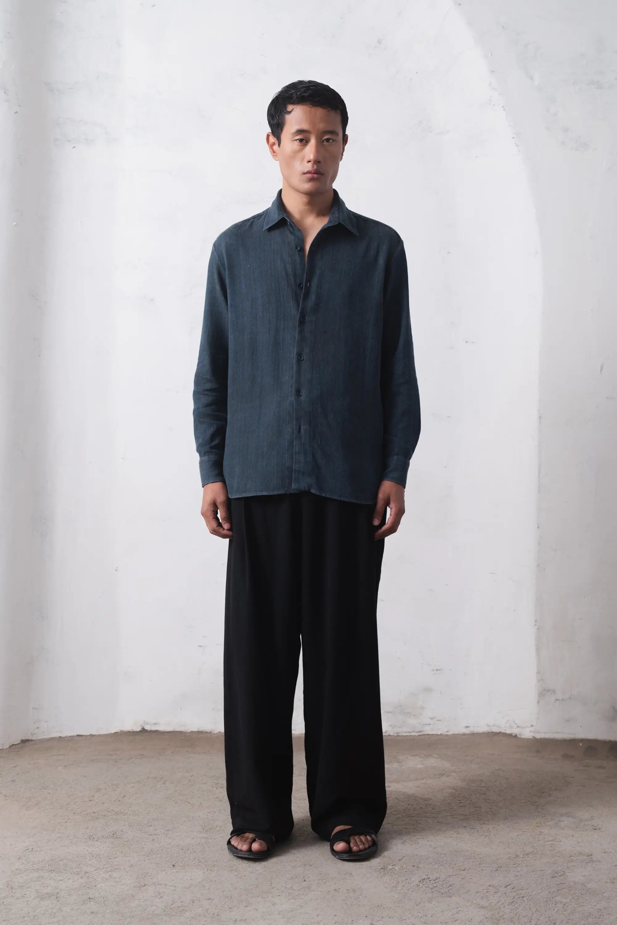 A man wearing indigo shirt with black trouser
