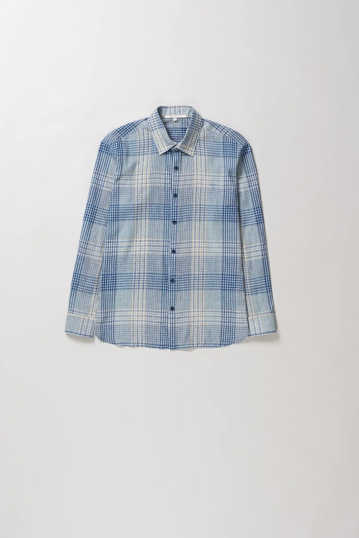 A long-sleeve button-up shirt with a blue, white, and light grey plaid pattern, displayed flat against a light grey background.