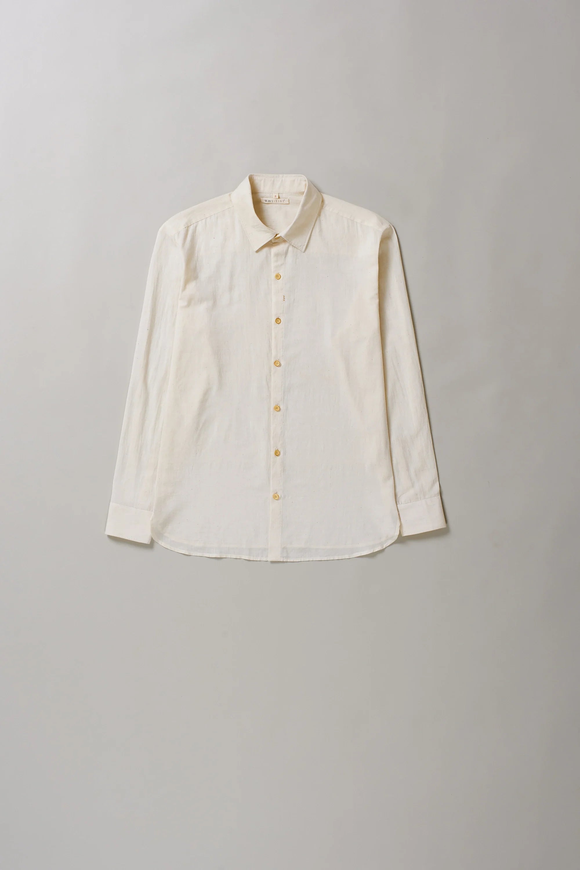 Front image of ecru cotton shirt on a grey background
