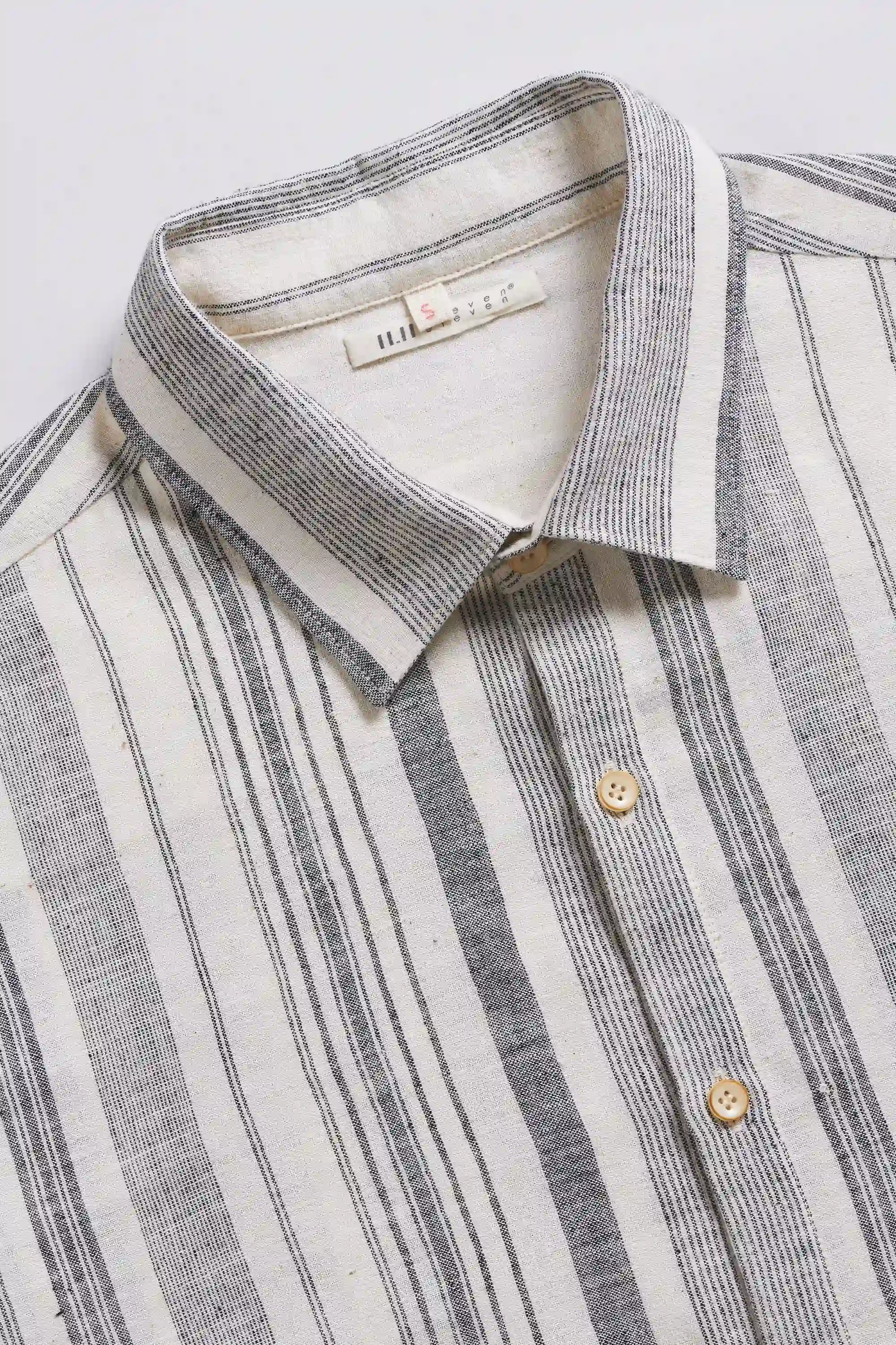 Close-up of a striped shirt with a collar and buttons on a light grey background