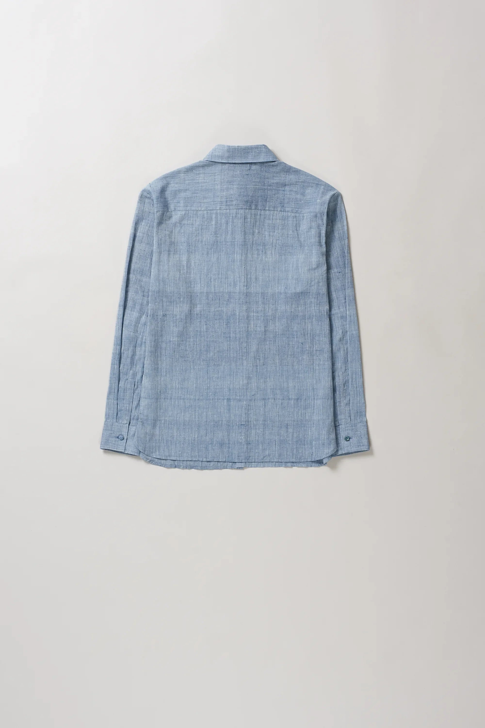 Back image of blue shirt on a light grey background