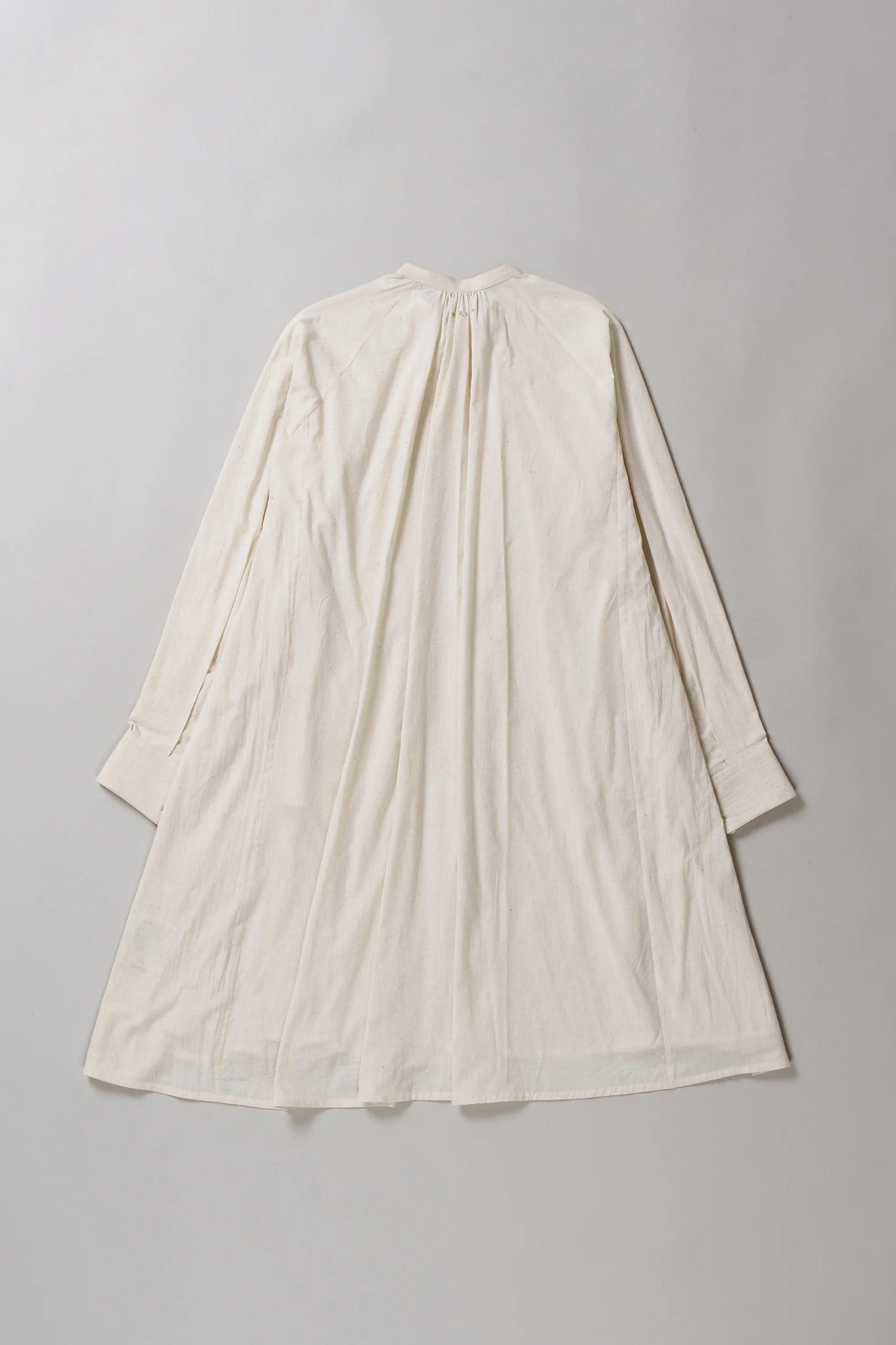 Ecru dress on a grey background