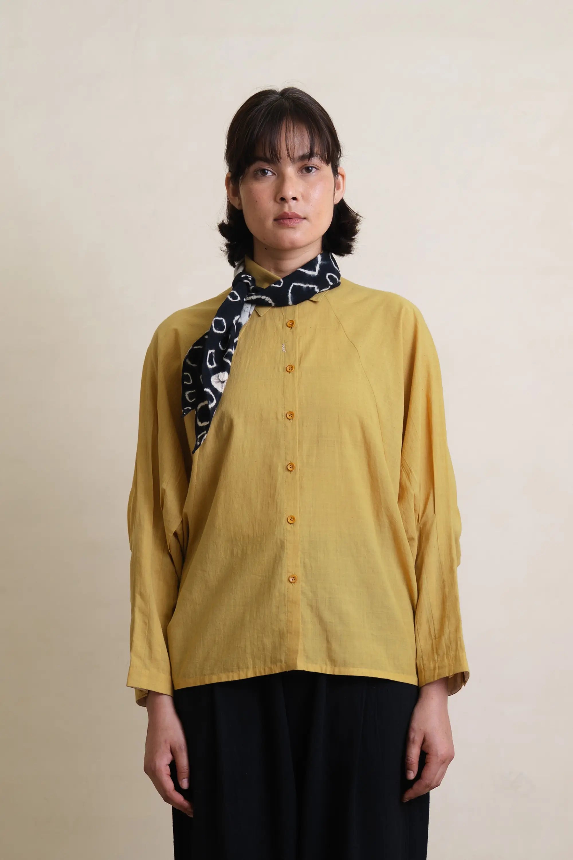 A woman wearing ochre yellow shirt