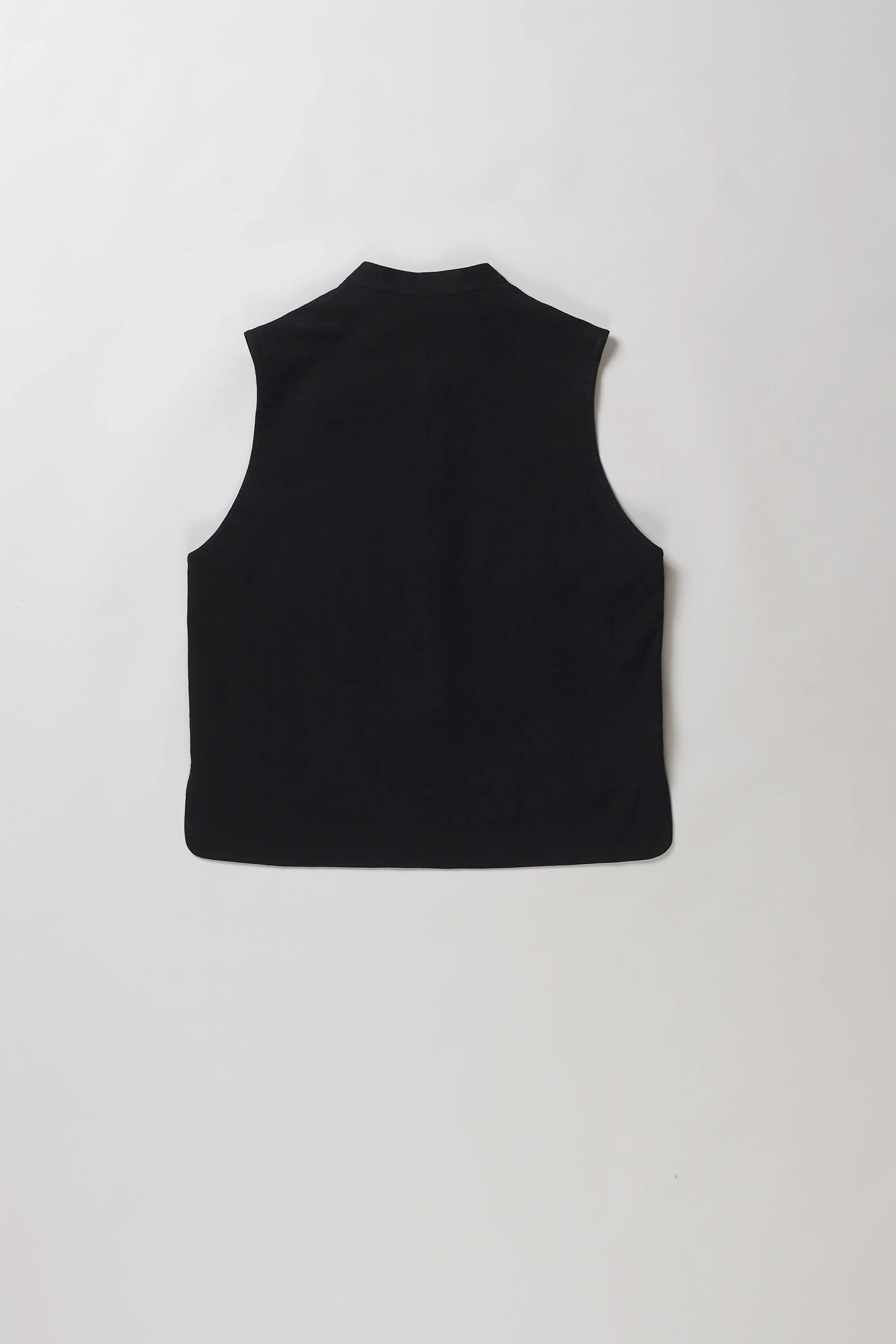 Back shot of black sleeveless vest with a mandarin collar and front button closure, laid flat against a light grey background.