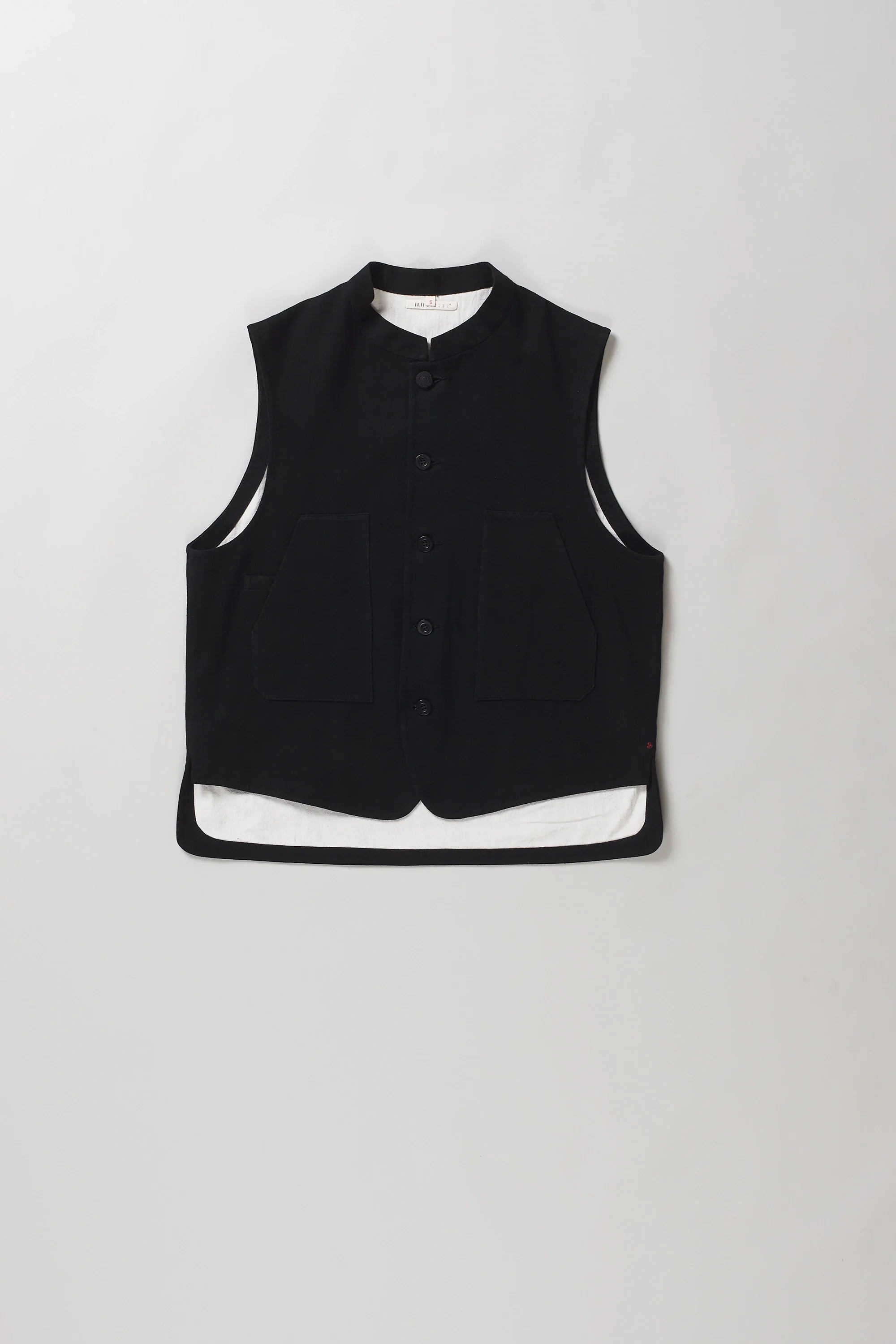 A black sleeveless vest with a mandarin collar and front button closure, laid flat against a light grey background.
