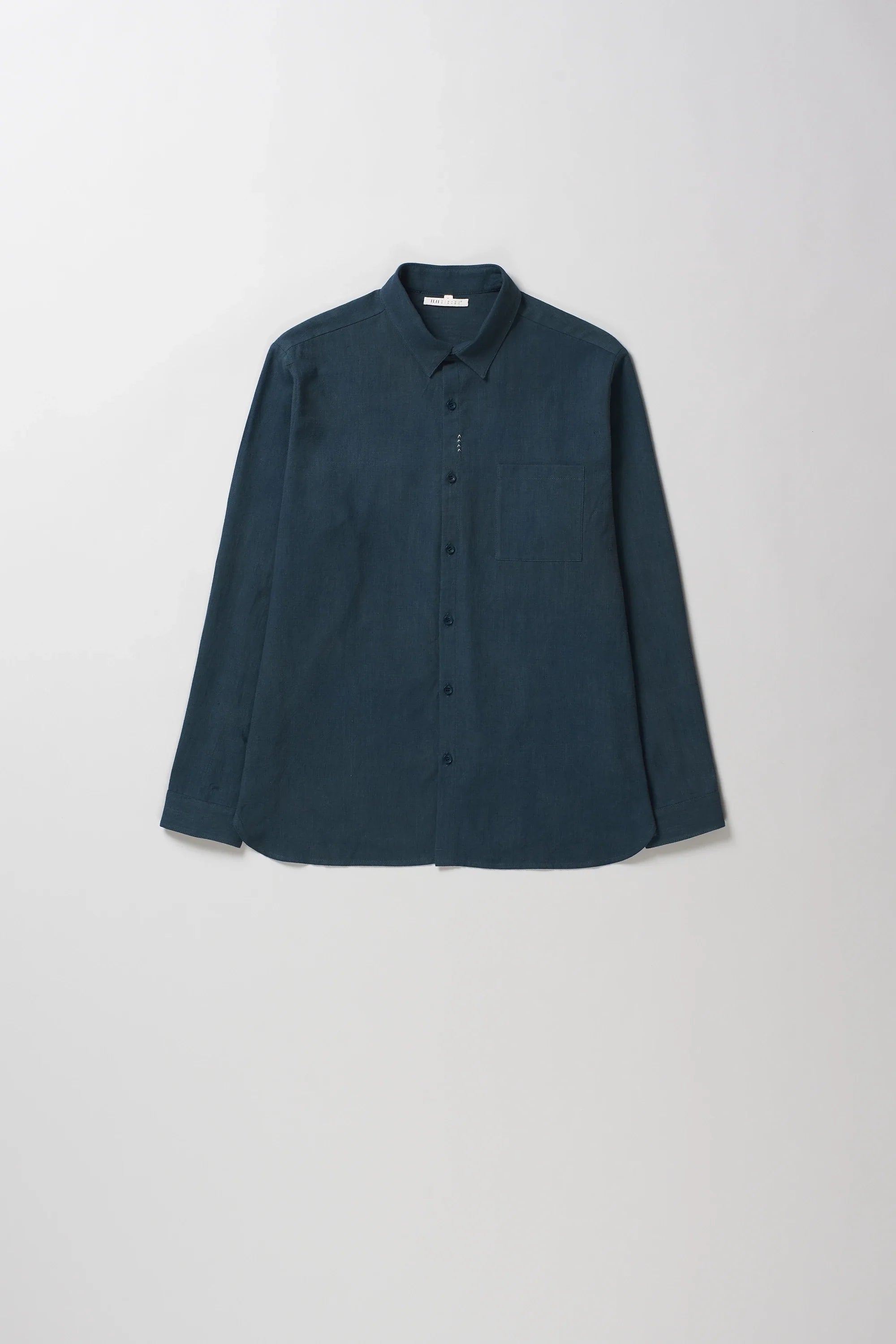 Black indigo long-sleeve button-up shirt with a pointed collar, laid flat against a light gray background.