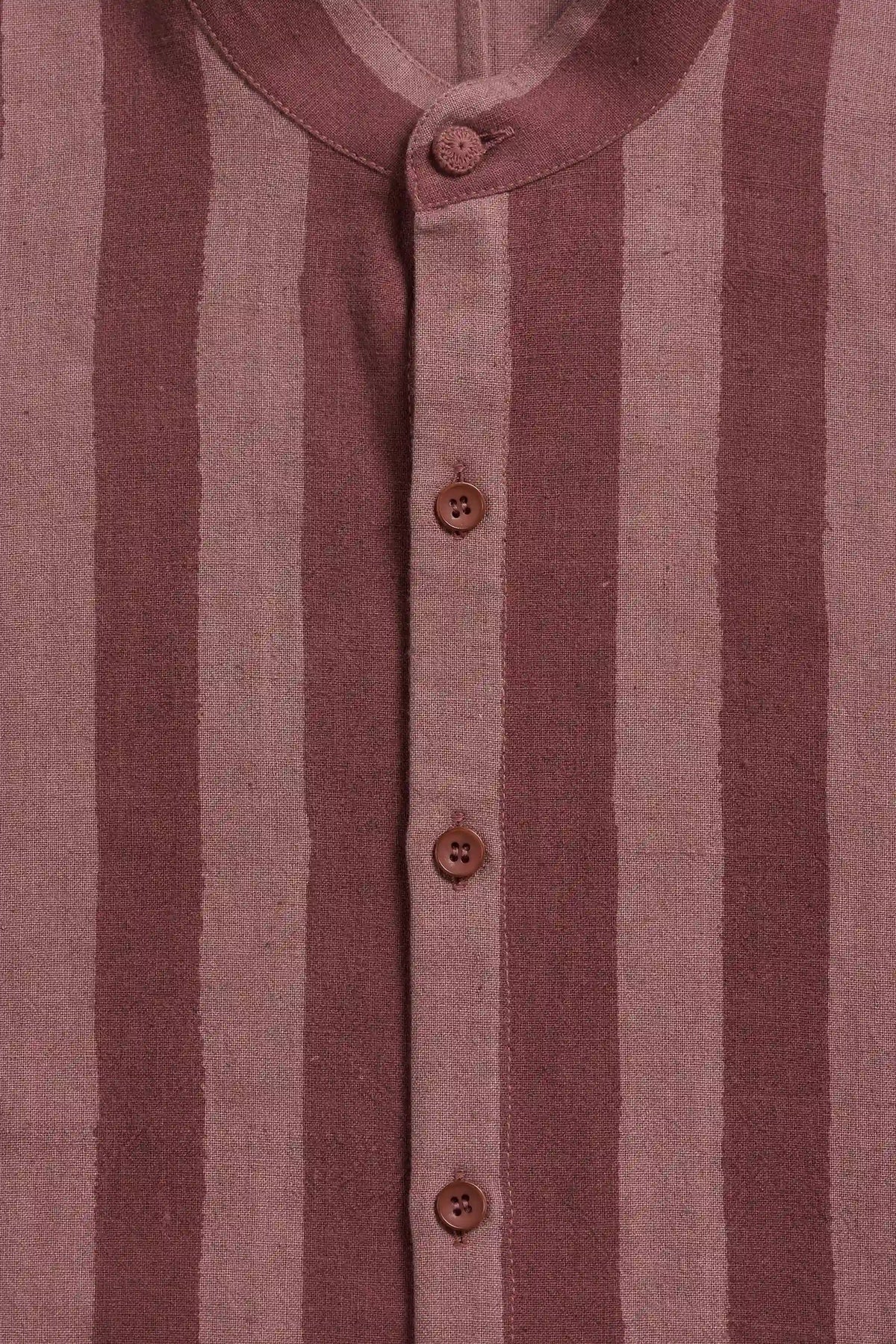 Close-up of a striped button-up shirt in dusty rose and muted mauve, featuring a mandarin collar and brown buttons.