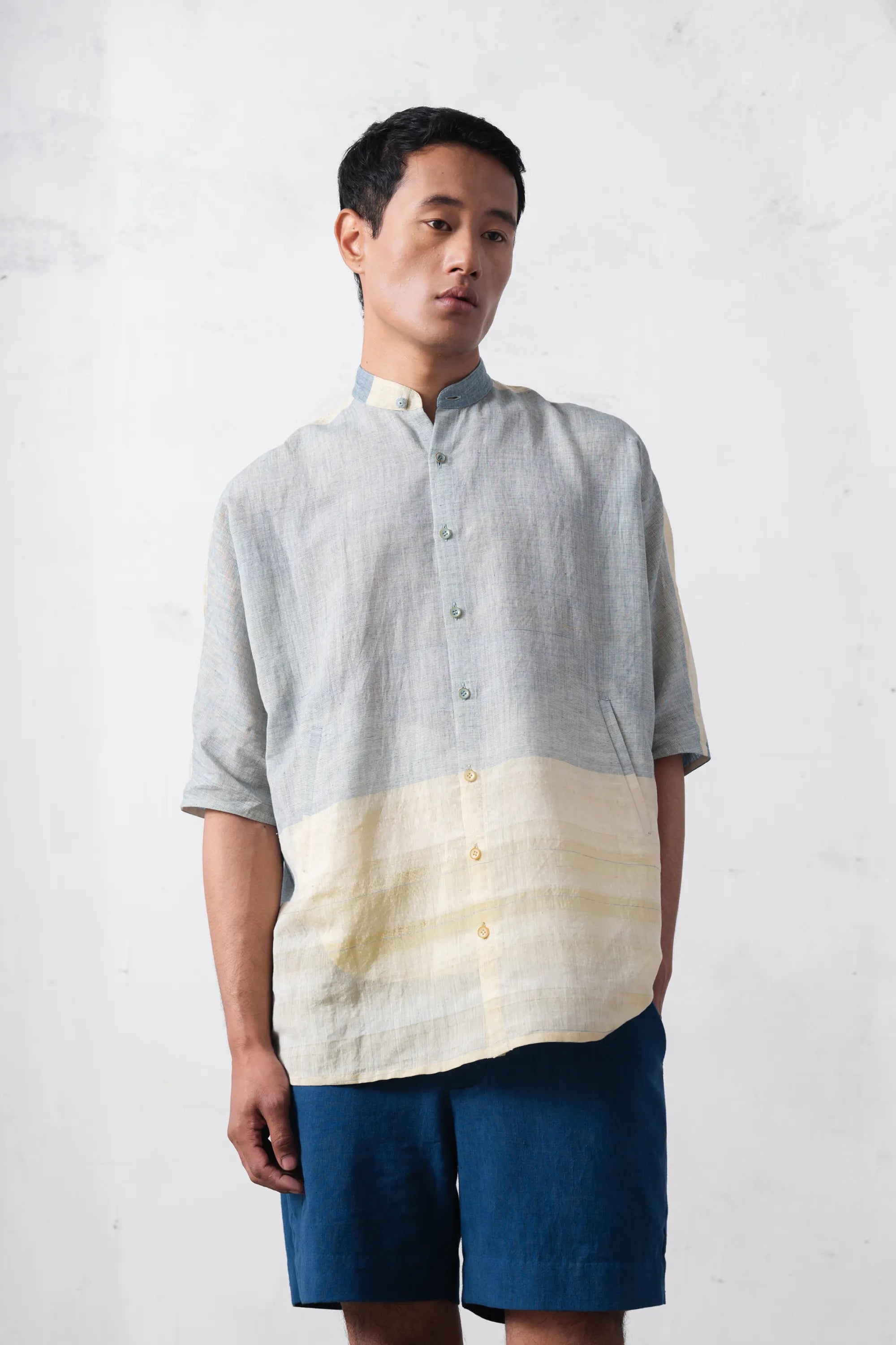 Man wearing a two-tone shirt with a plain background