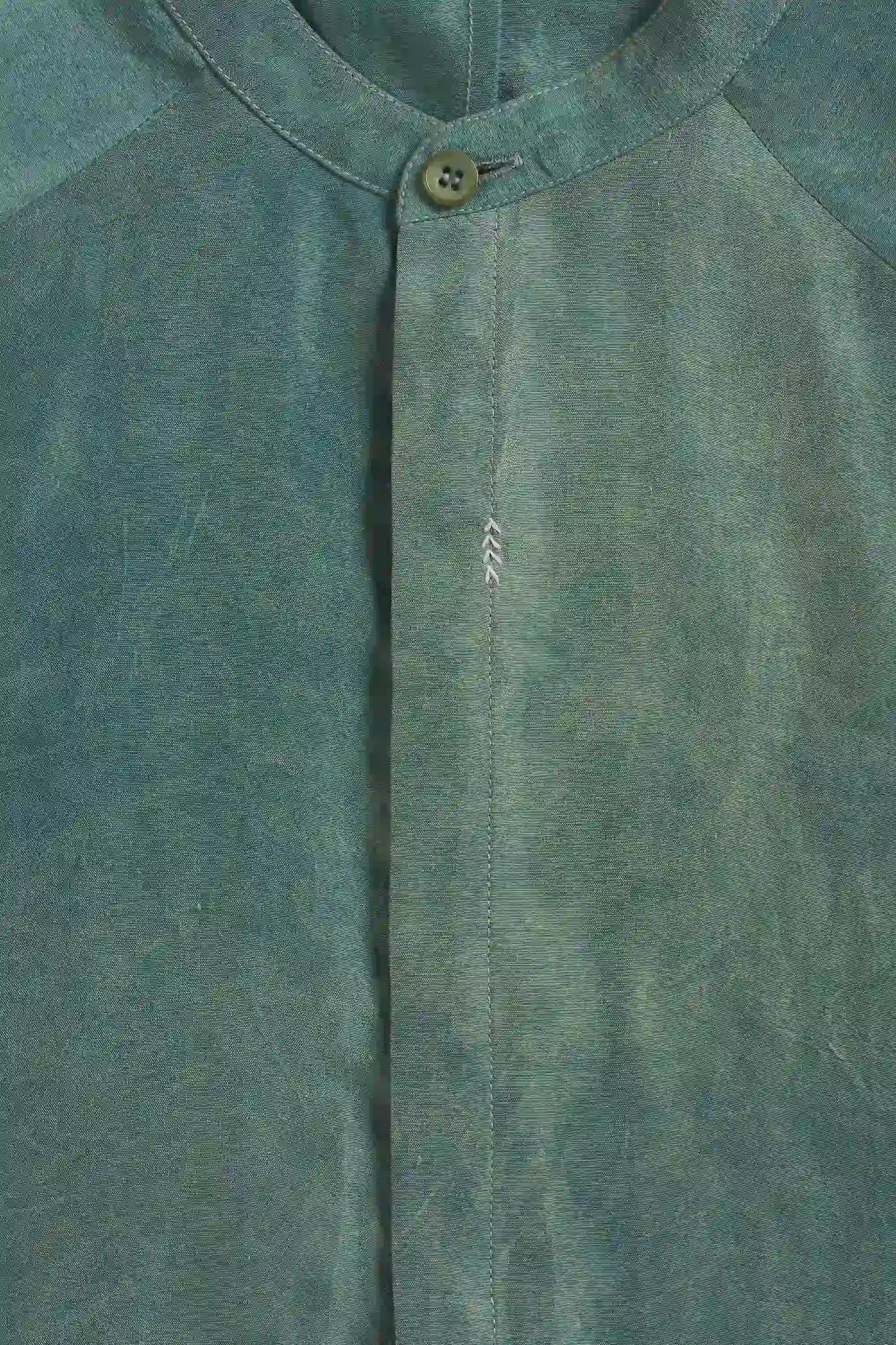 Close-up of a fabric with a button and  hand detailing