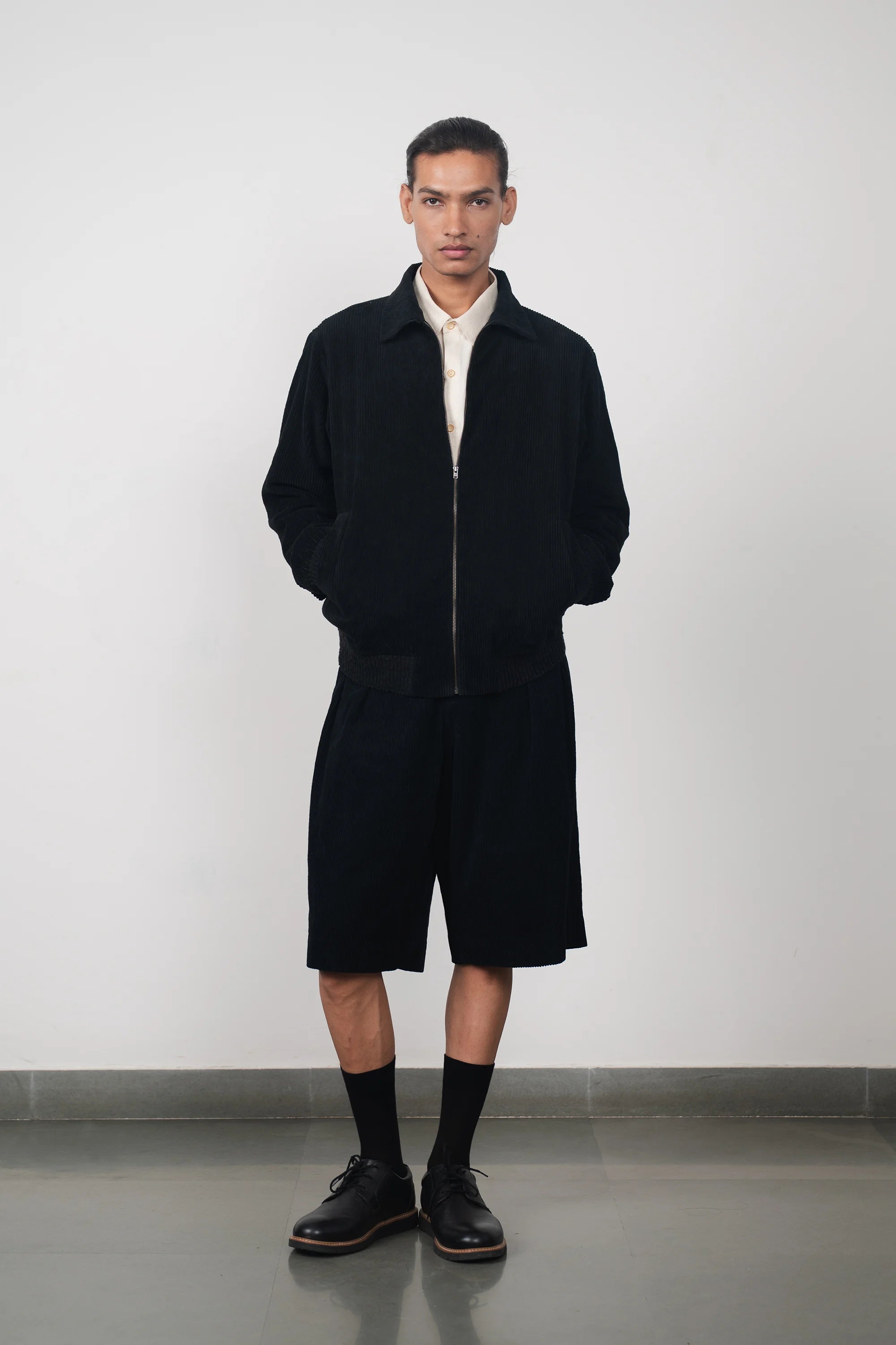 A man wearing black cotton jacket in black with shorts
