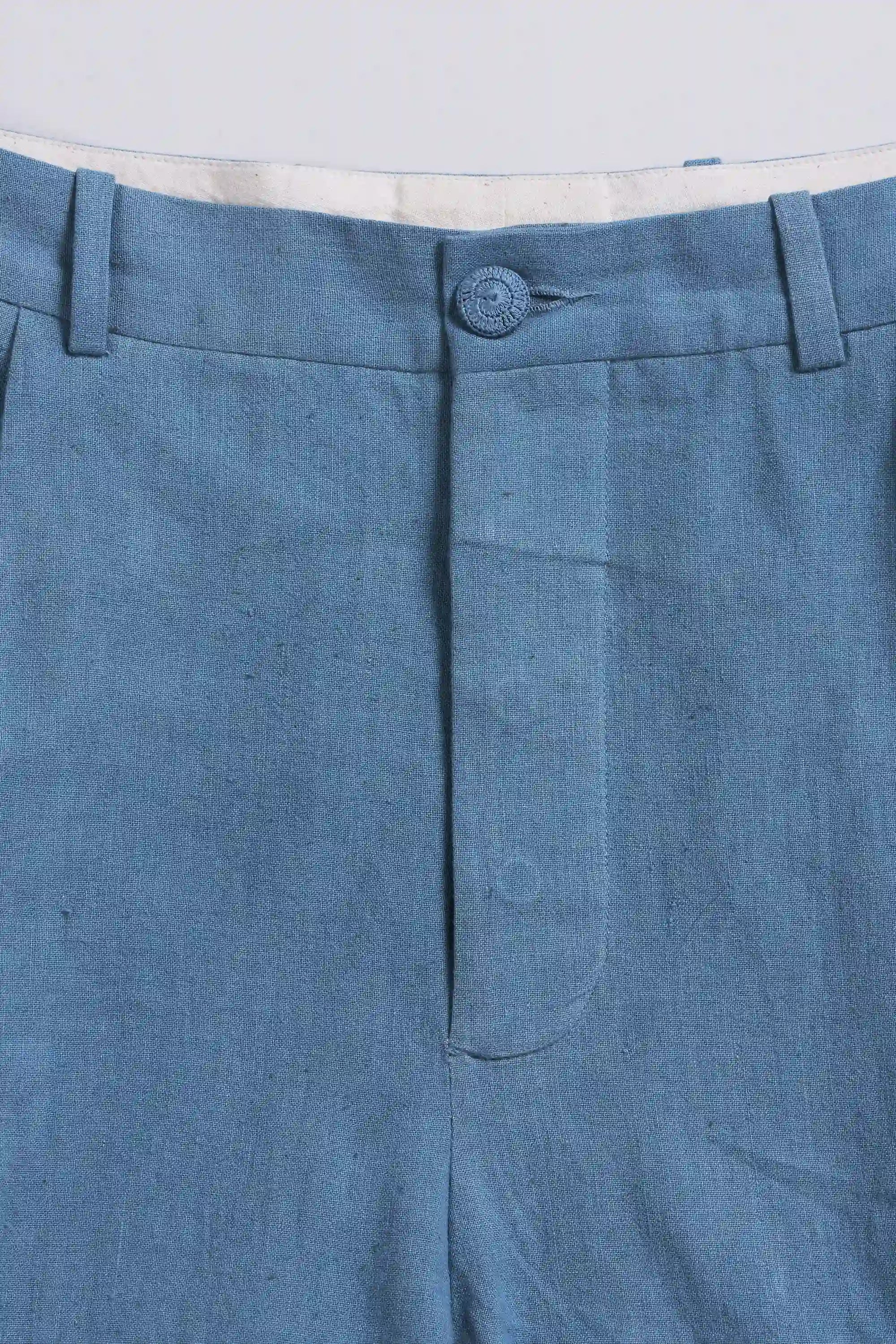 Close-up of blue pants with a button on a light grey background