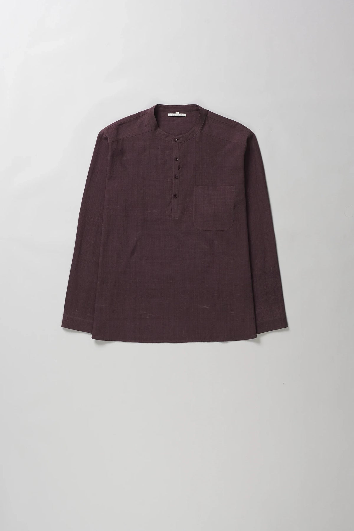 A purple red colored long-sleeve shirt with a buttoned mandarin collar and a chest pocket, laid flat against a light grey background.