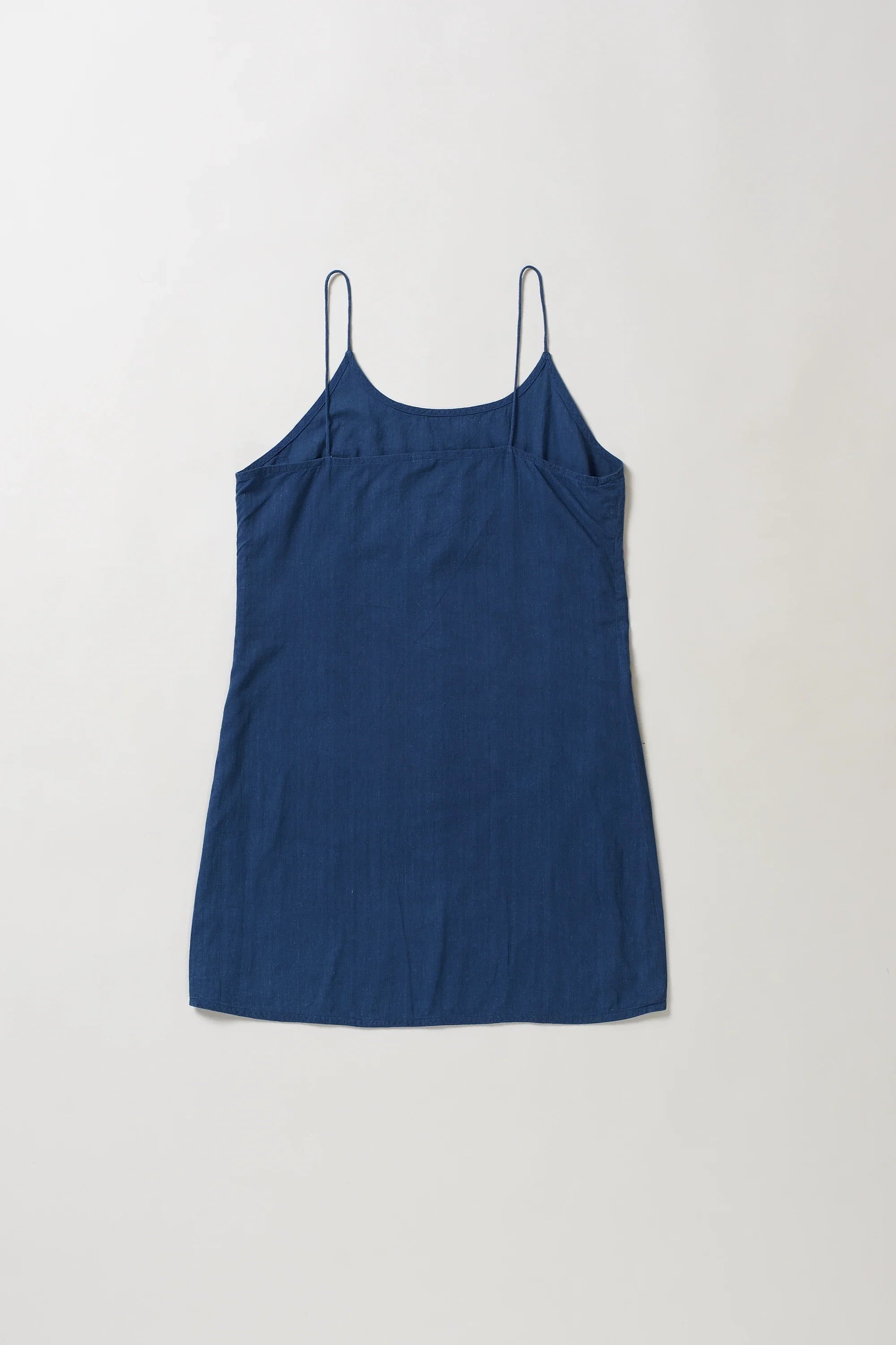 Back image of blue slip dress on a light grey background