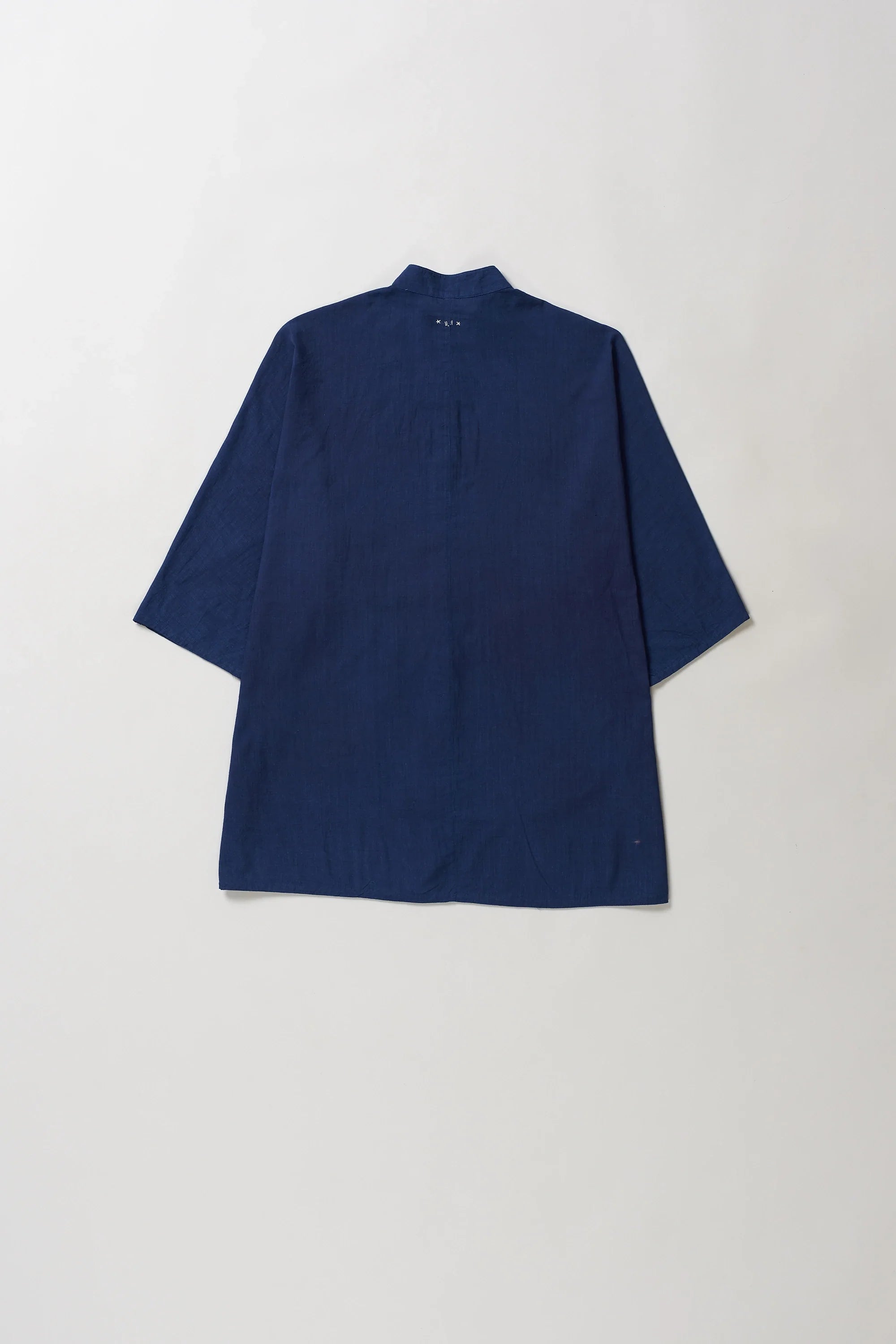 Back image of blue shirt on a light grey background
