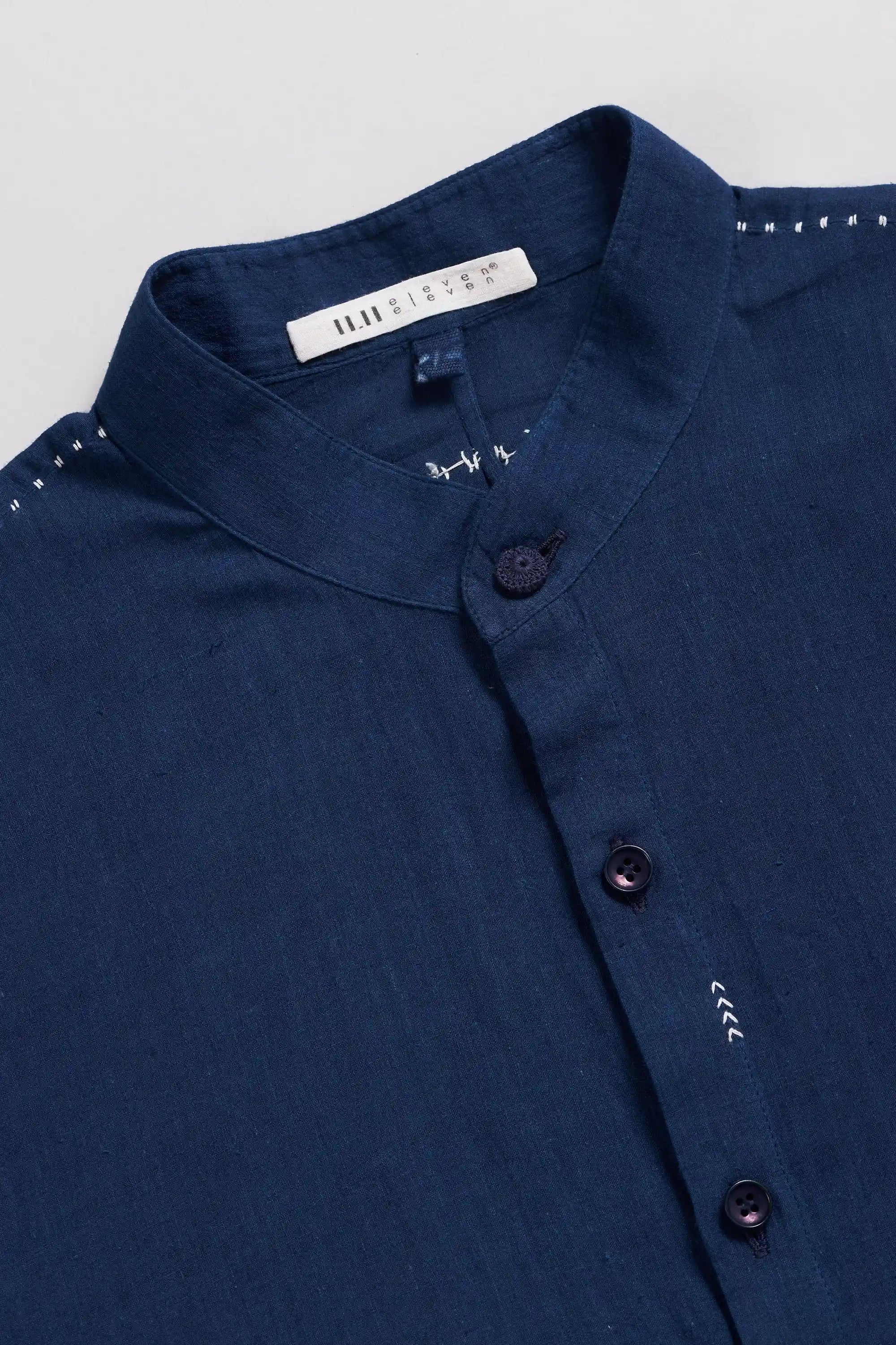Close-up of a blue shirt with buttons on a light grey background