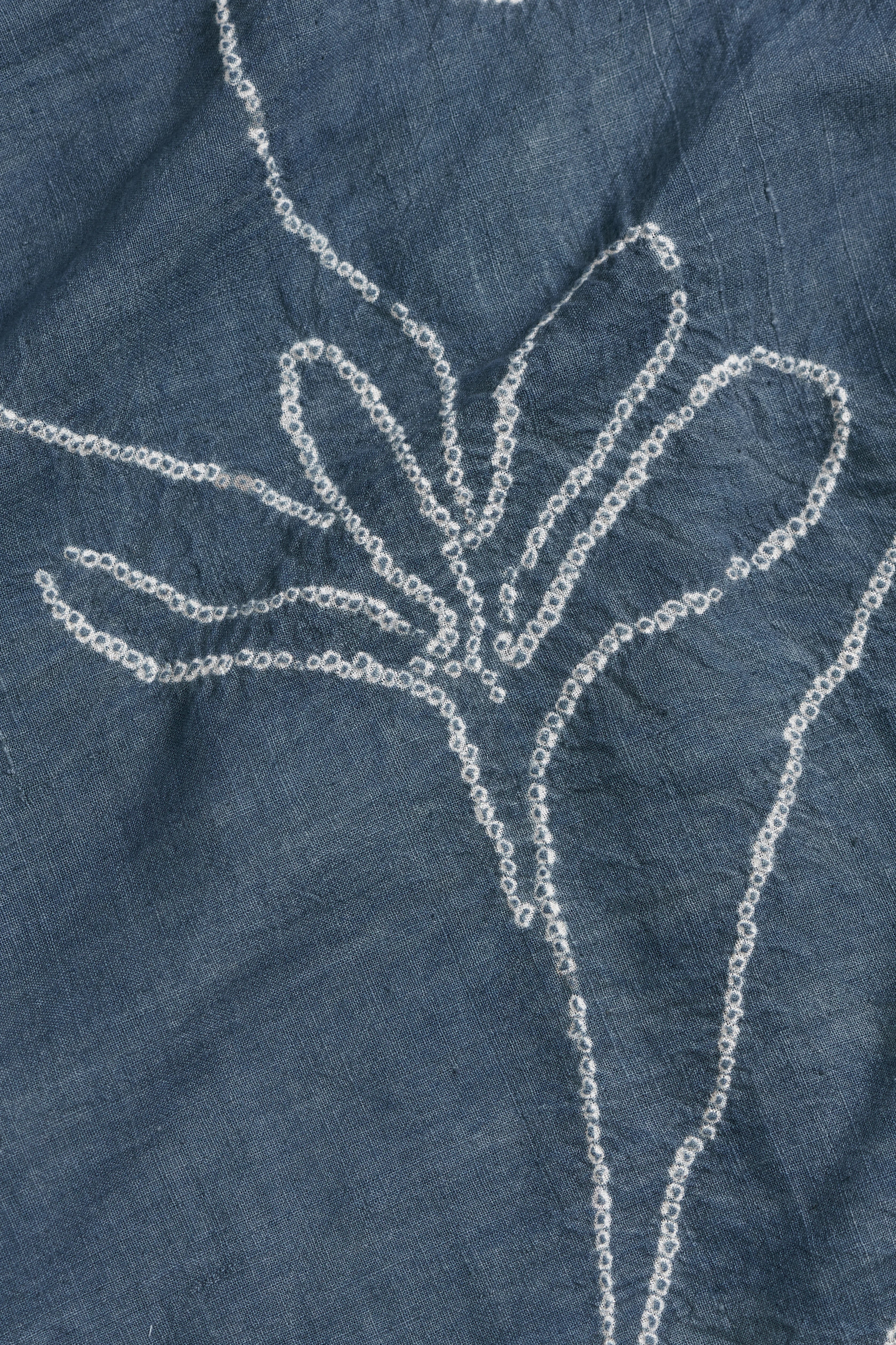 Close-up of a blue fabric with bandhani floral design