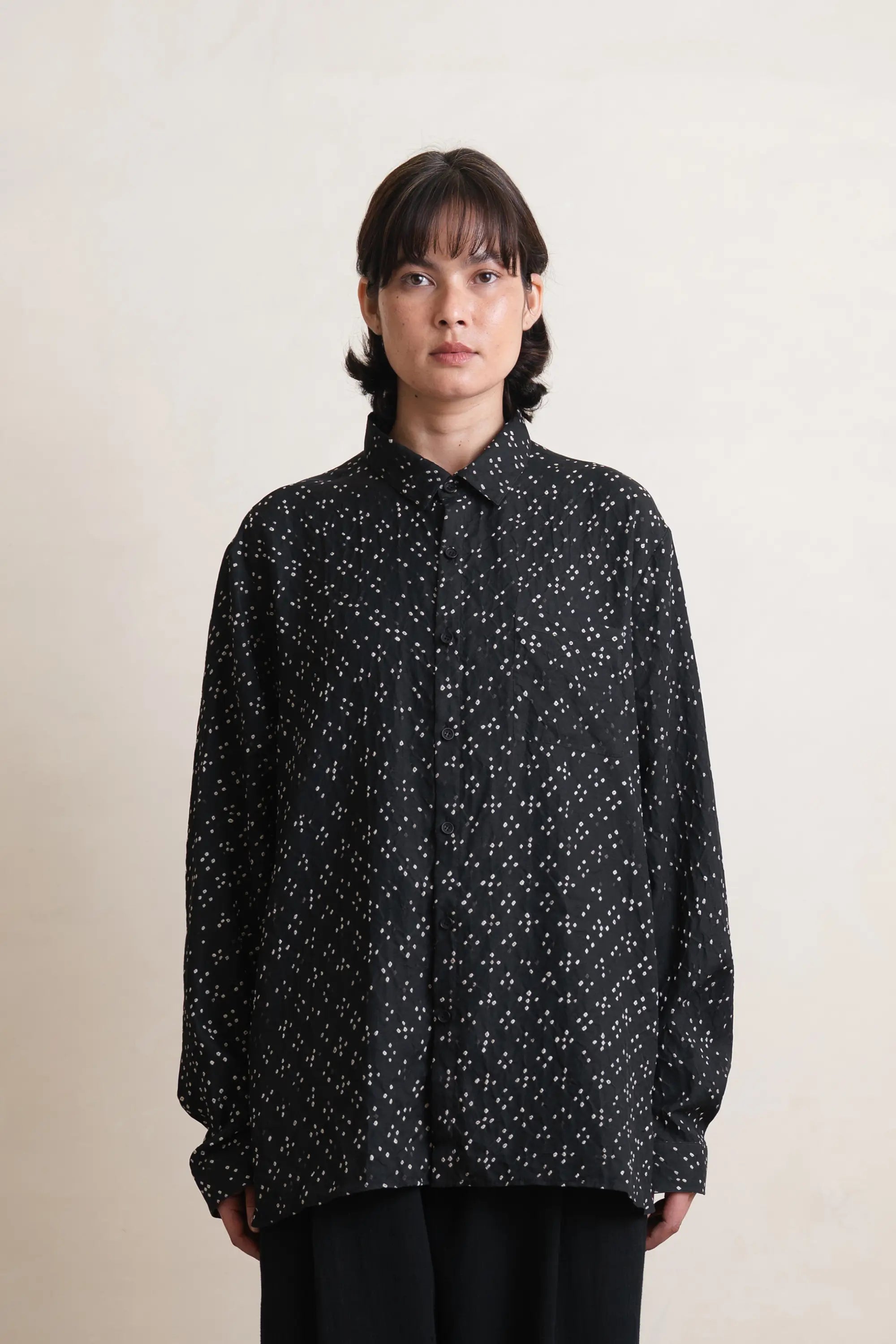 A woman wearing black silk shirt