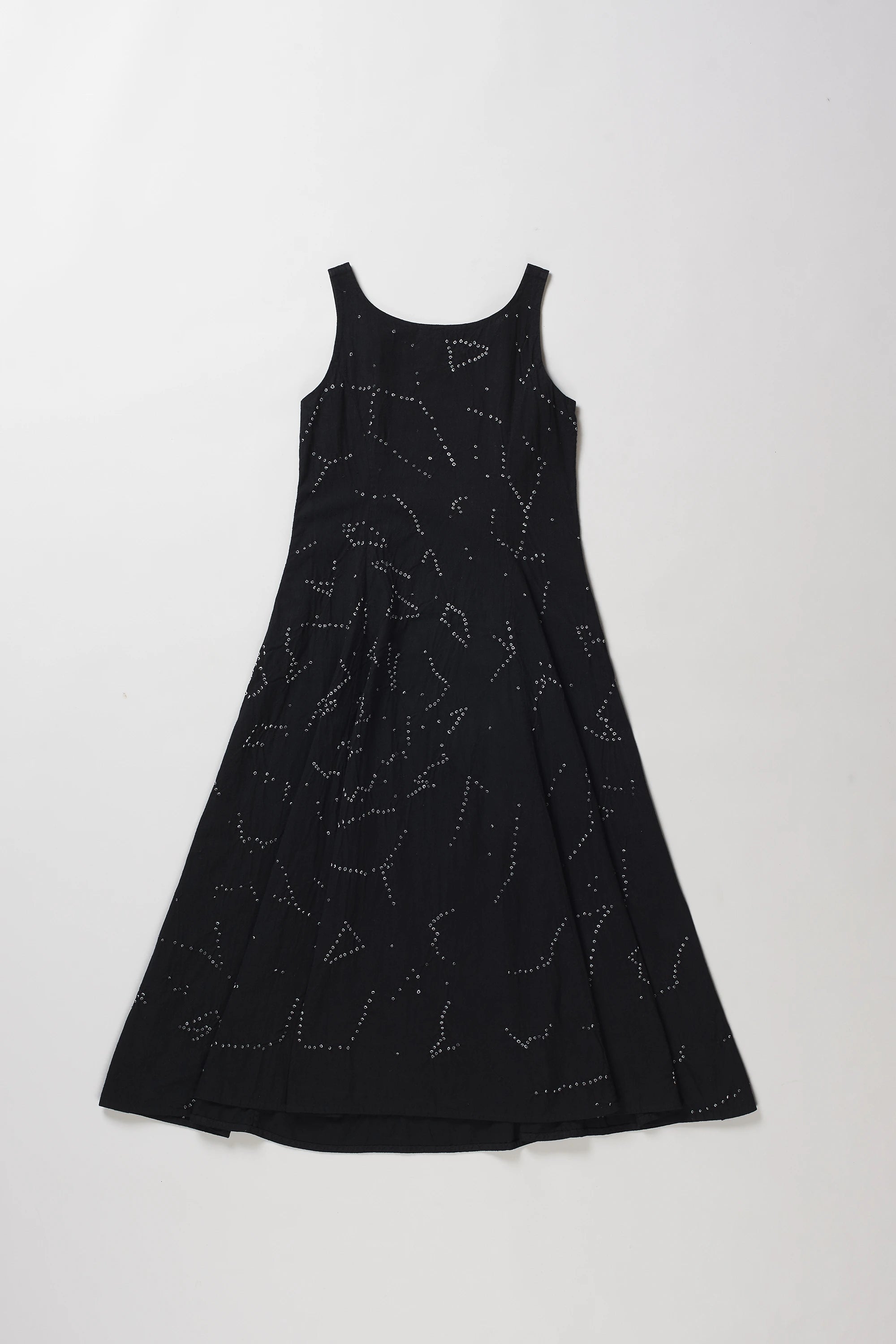 Back shot of sleeveless black A-line dress with a shibori pattern, displayed flat against a light grey background.