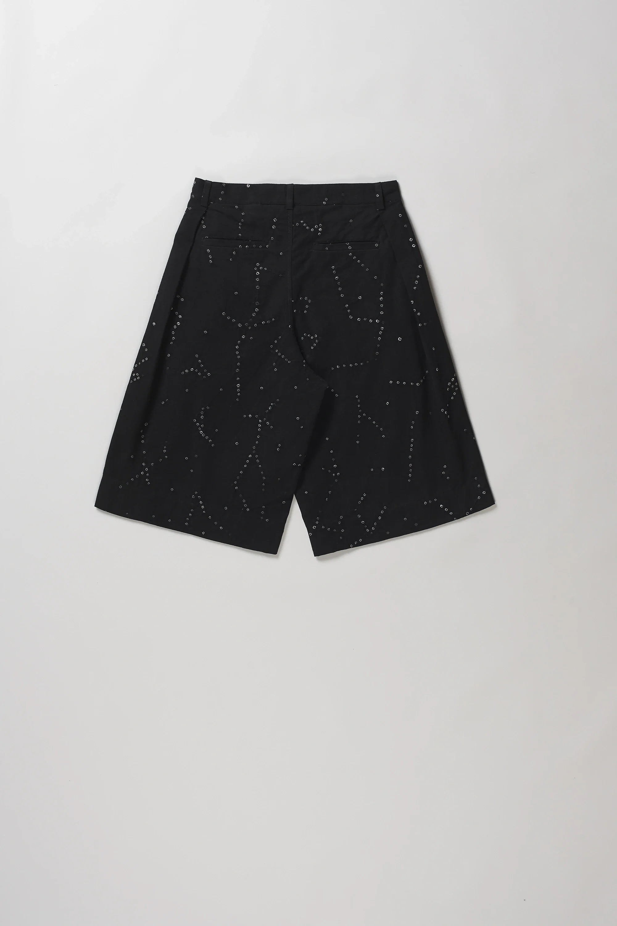 Black shot of back wide-leg shorts with a subtle white speckled constellation pattern, laid flat on a light grey background.