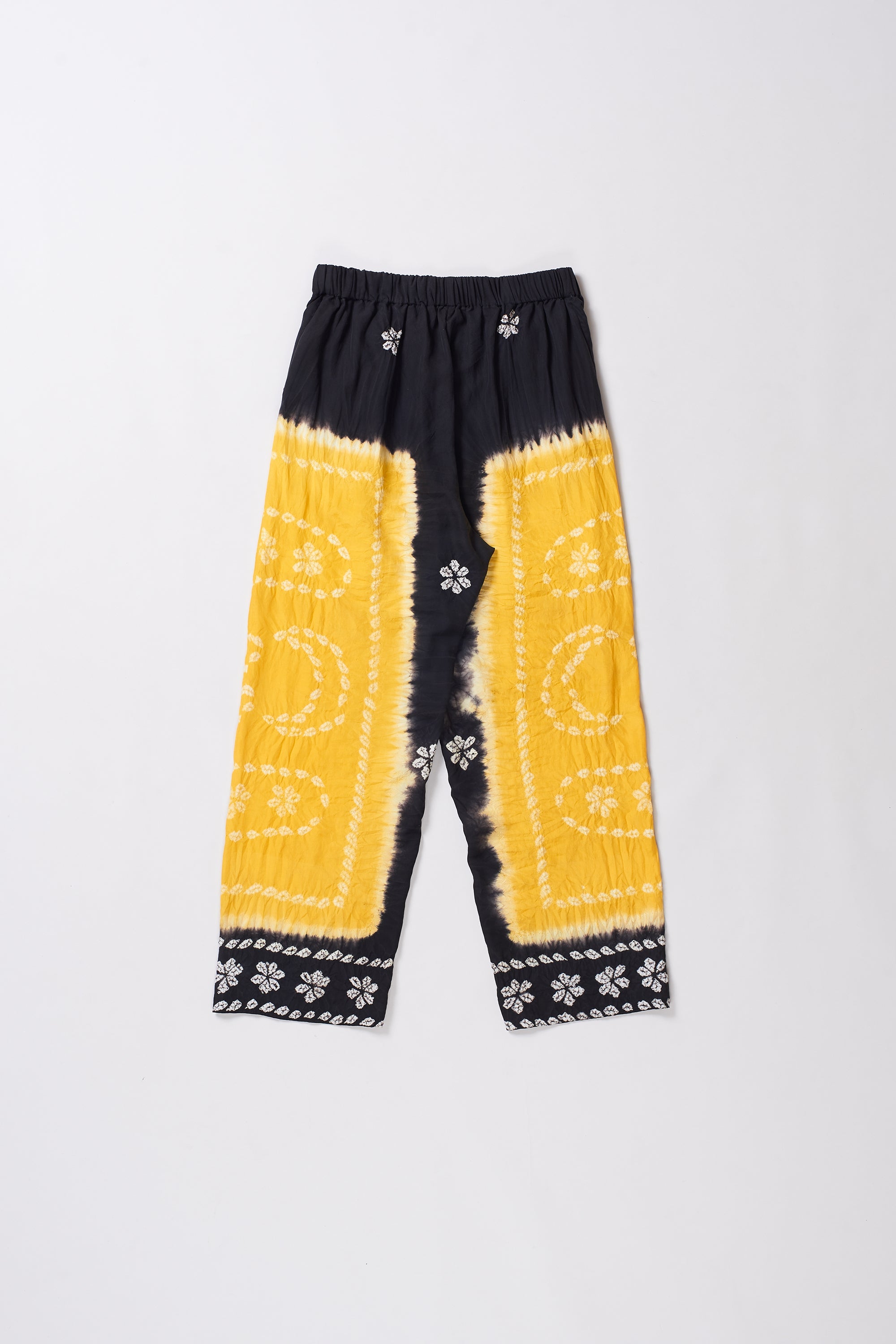 Black and yellow tie-dye pants with white patterns