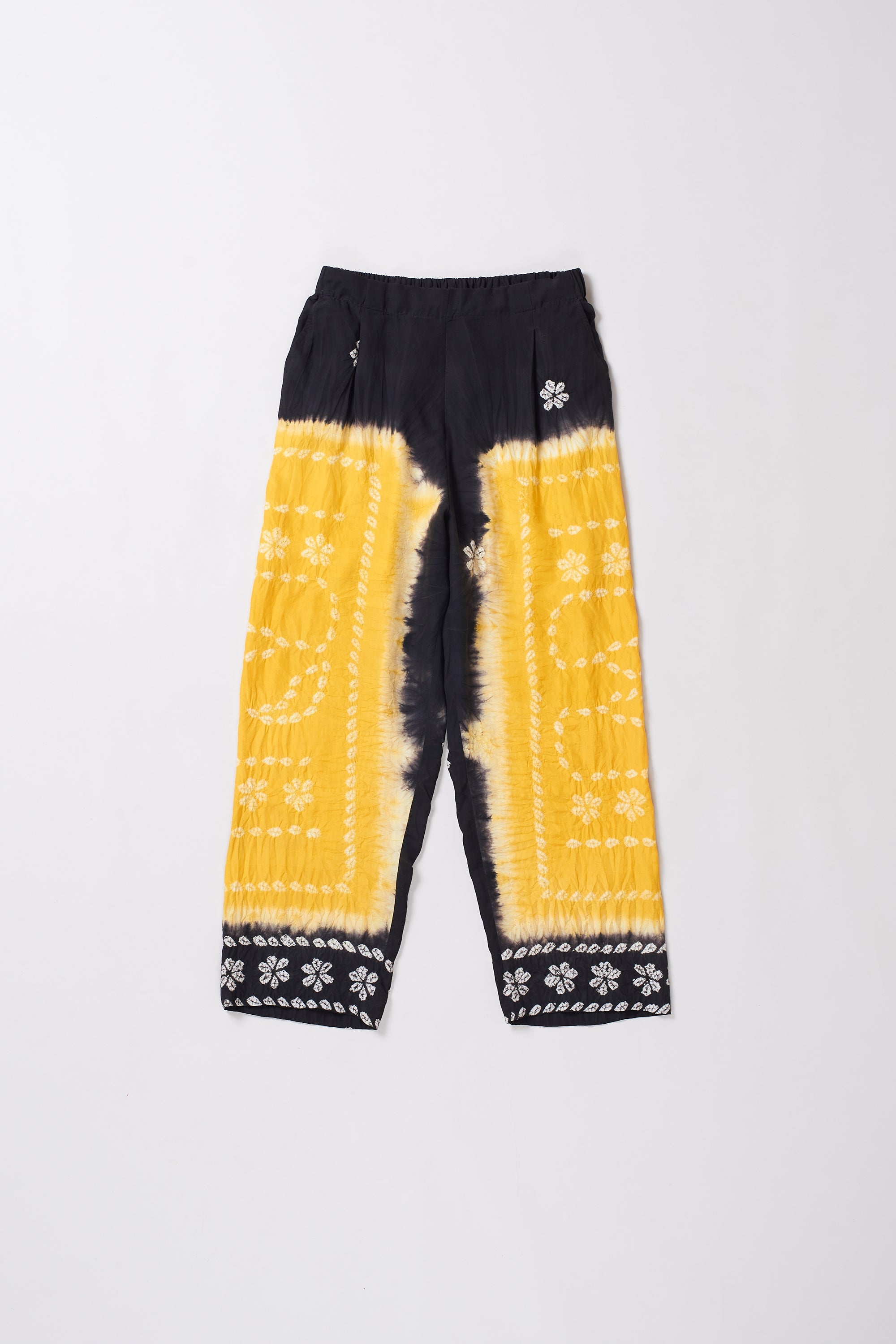 Yellow and black tie-dye pants with a paw print design