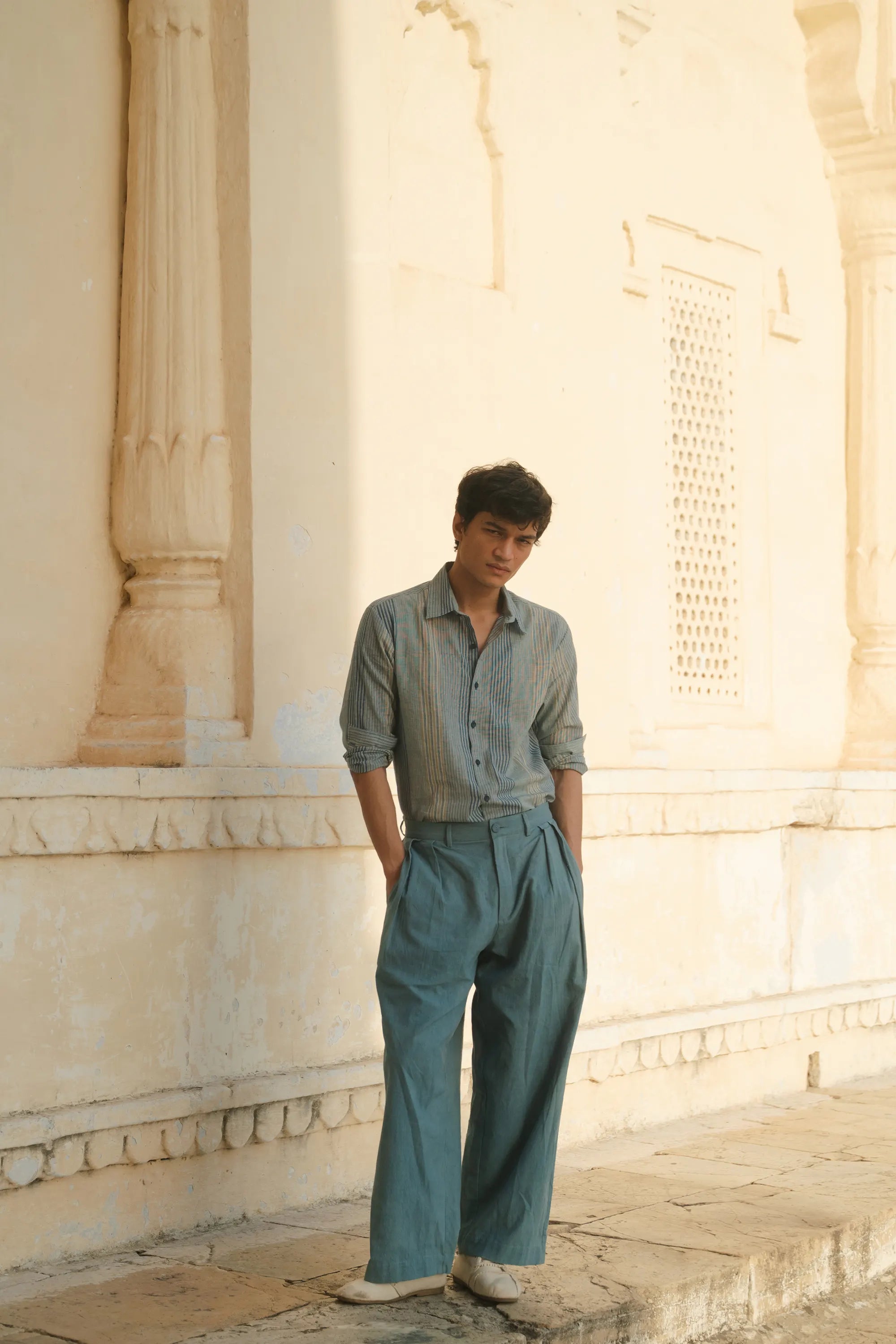 A man wearing powder blue pant with light blue shirt 