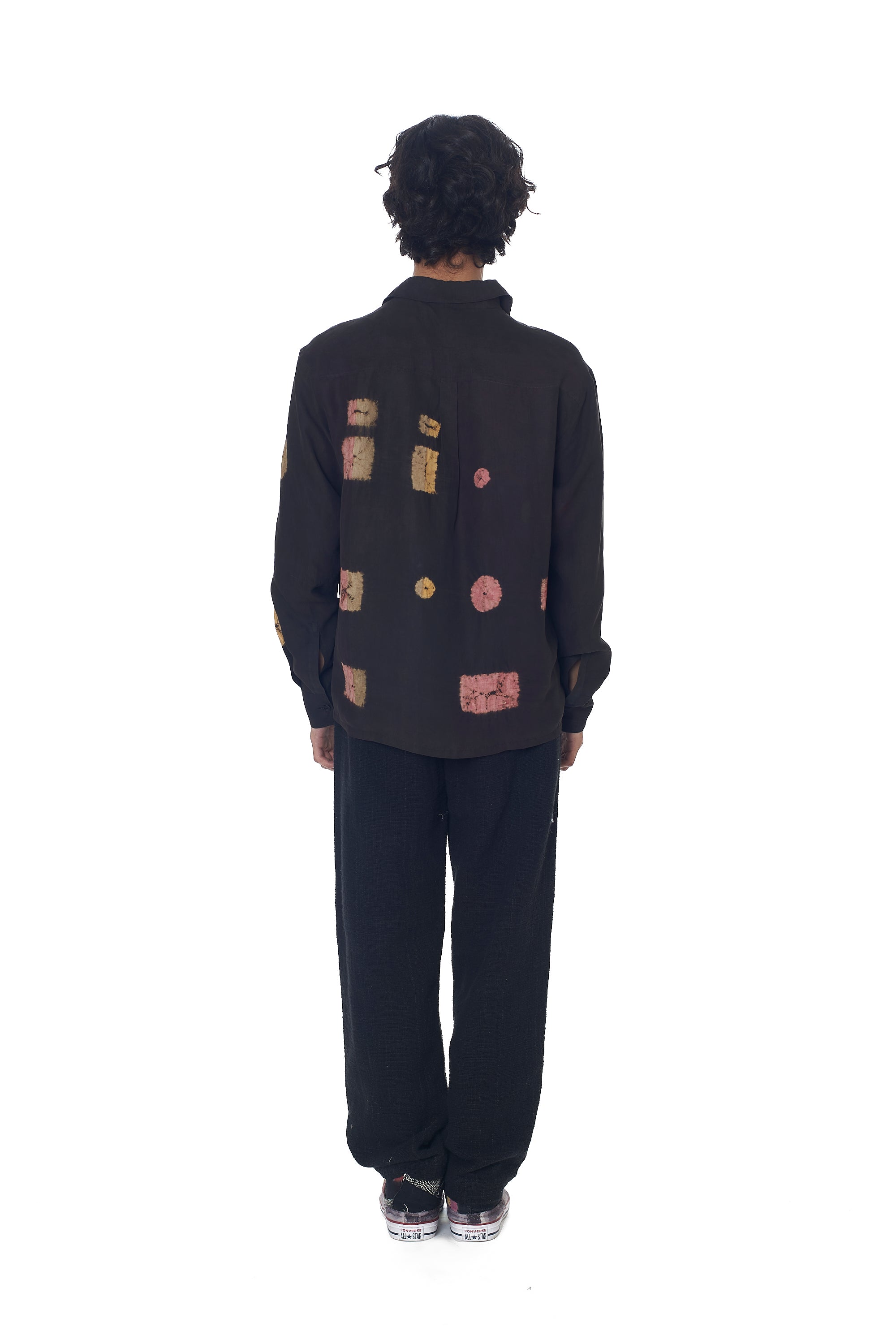 A back shot of a man wearing black pant