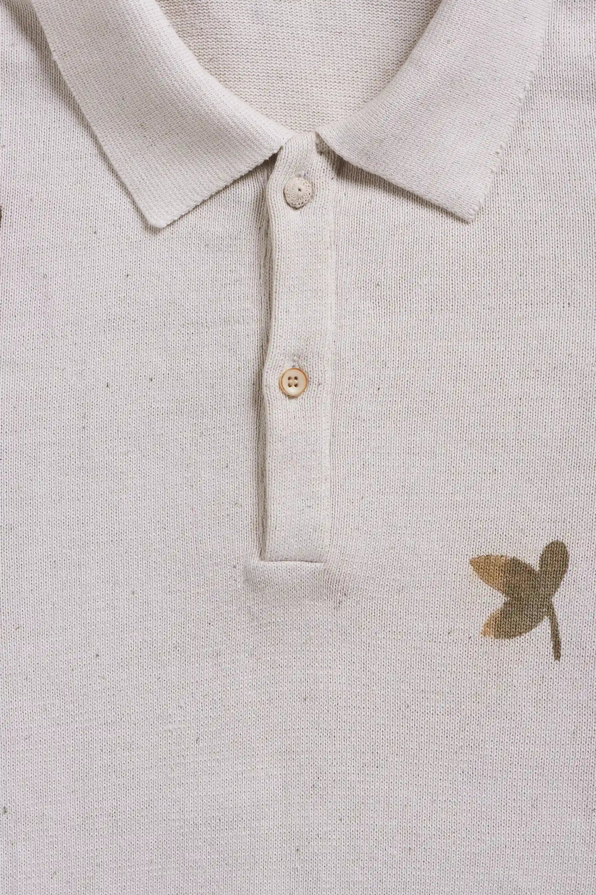 Close-up of a light-colored polo t-shirt with buttons on a white background