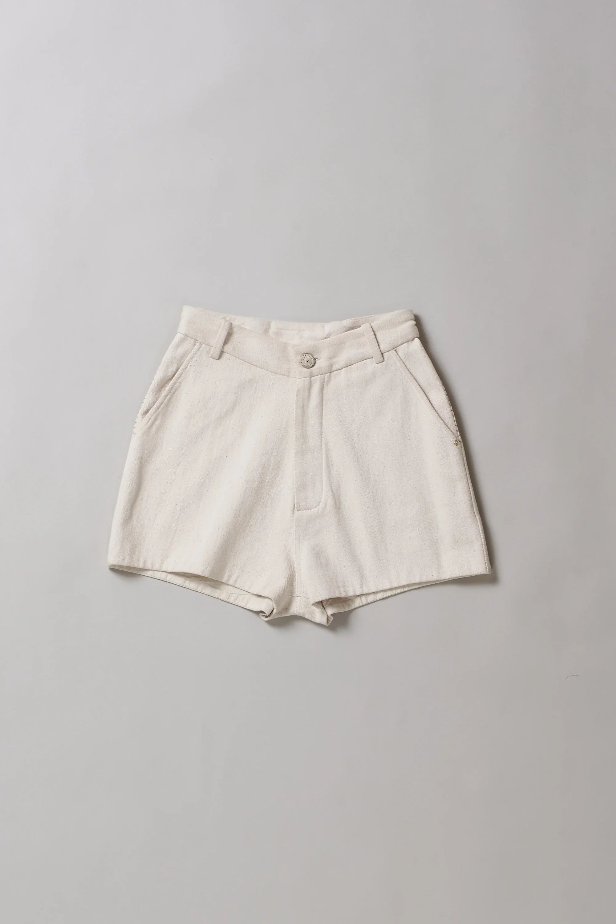 Ecru shorts on a grey background