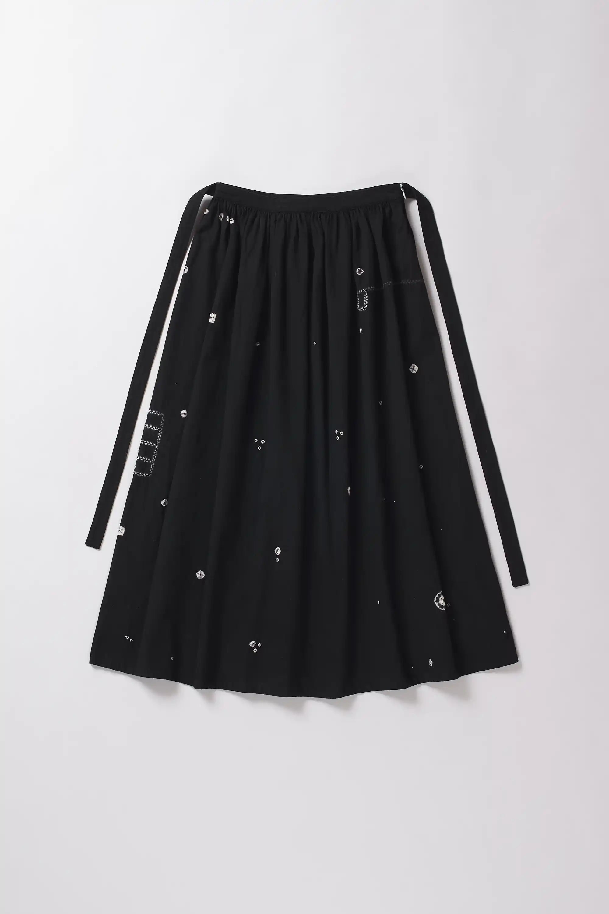 Black skirt with white Shibori accents on a grey background
