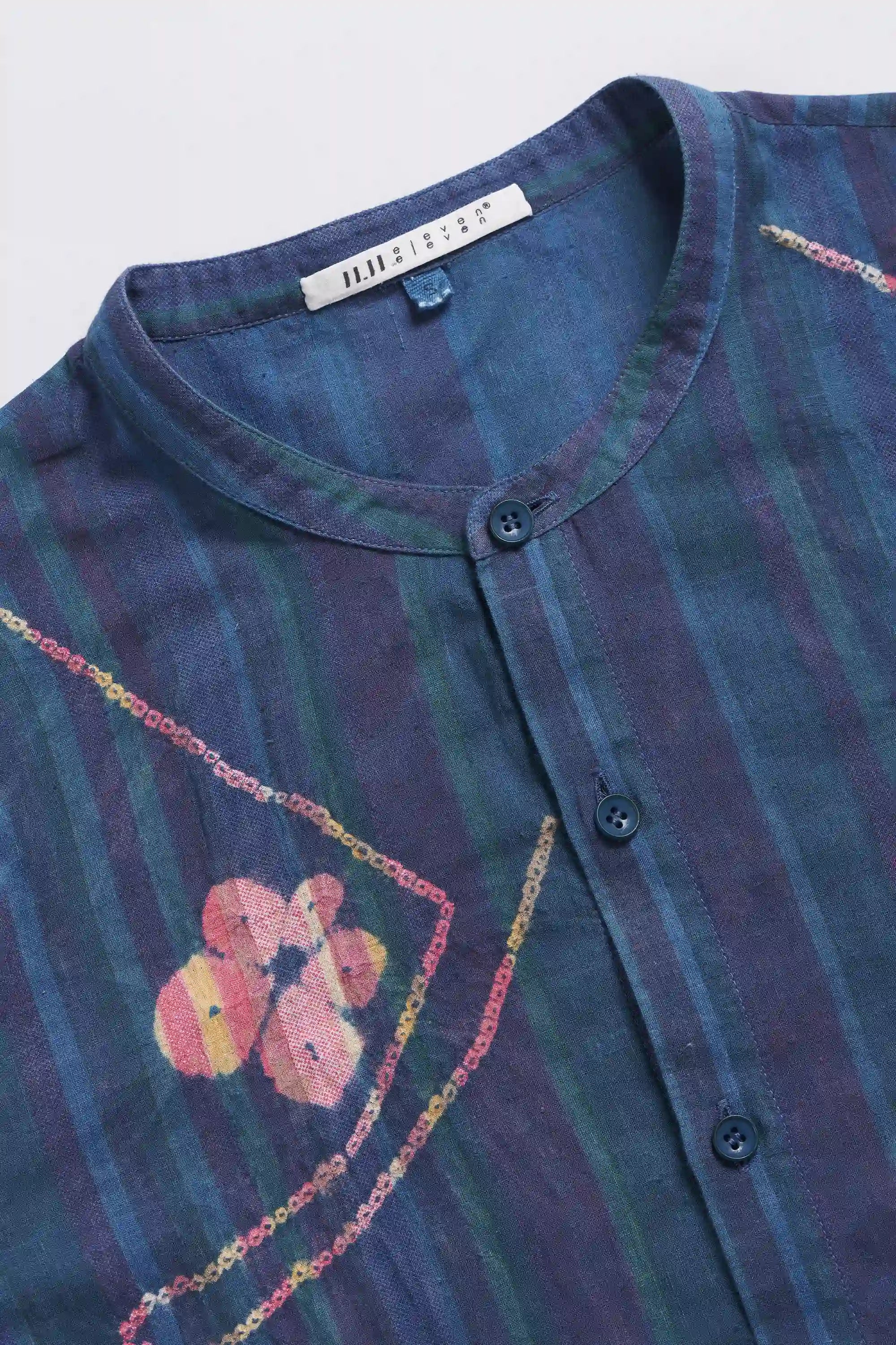 Close-up of a blue and purple striped shirt with hand shibori on a white background