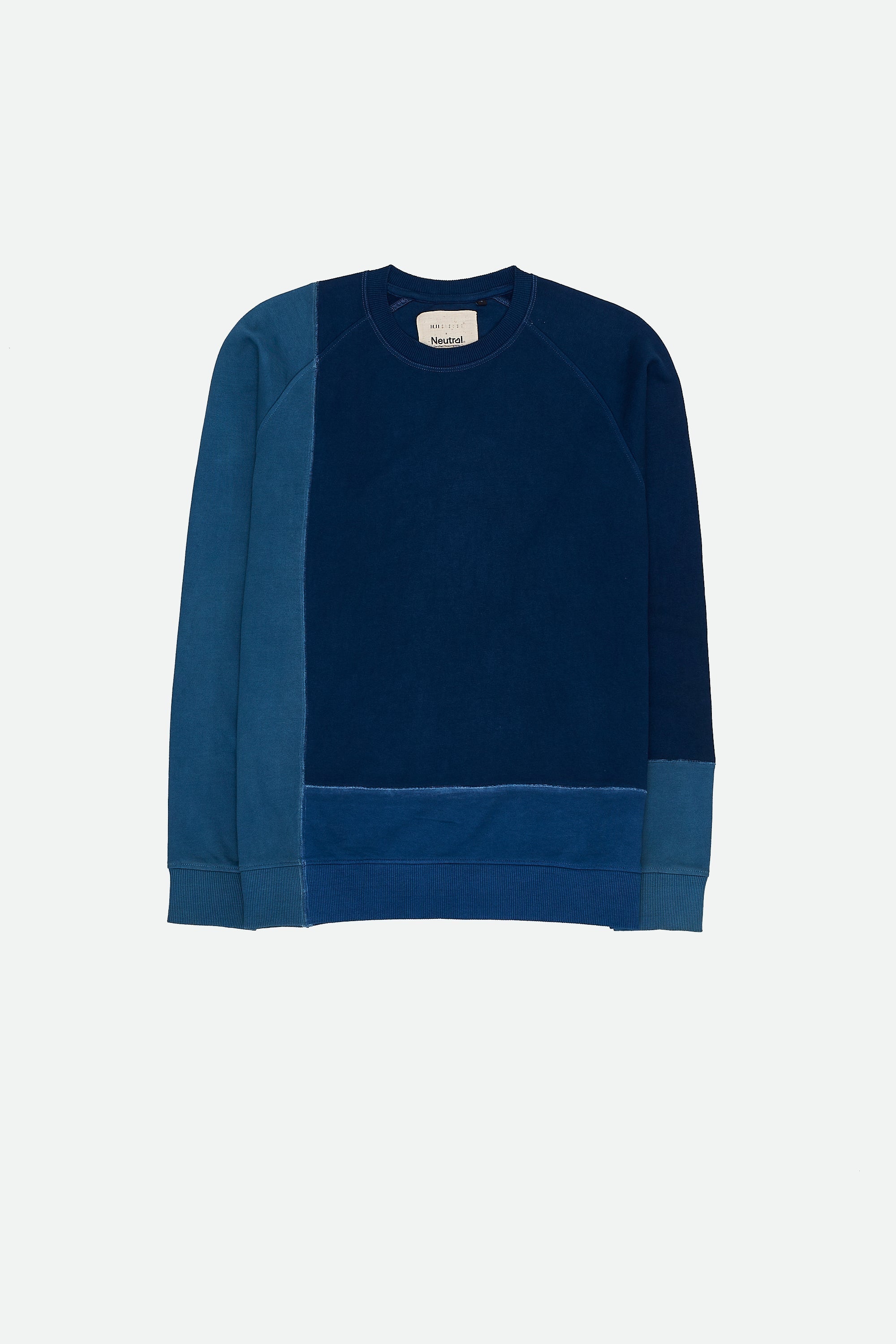 A blue indigo patchwork cotton sweatshirt with long sleeves, displayed against a light grey background