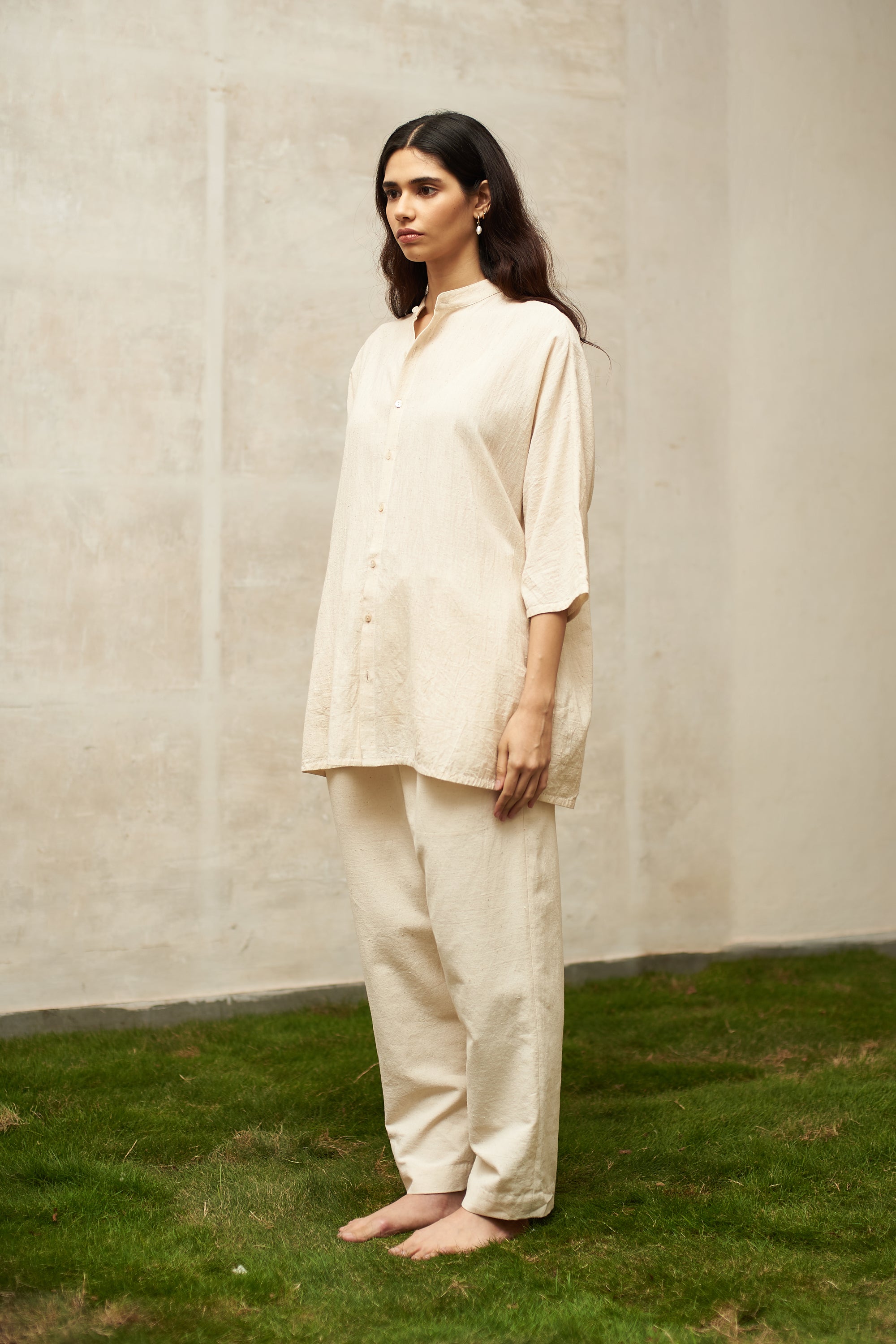 A back shot of a woman wearing ecru cotton shirt