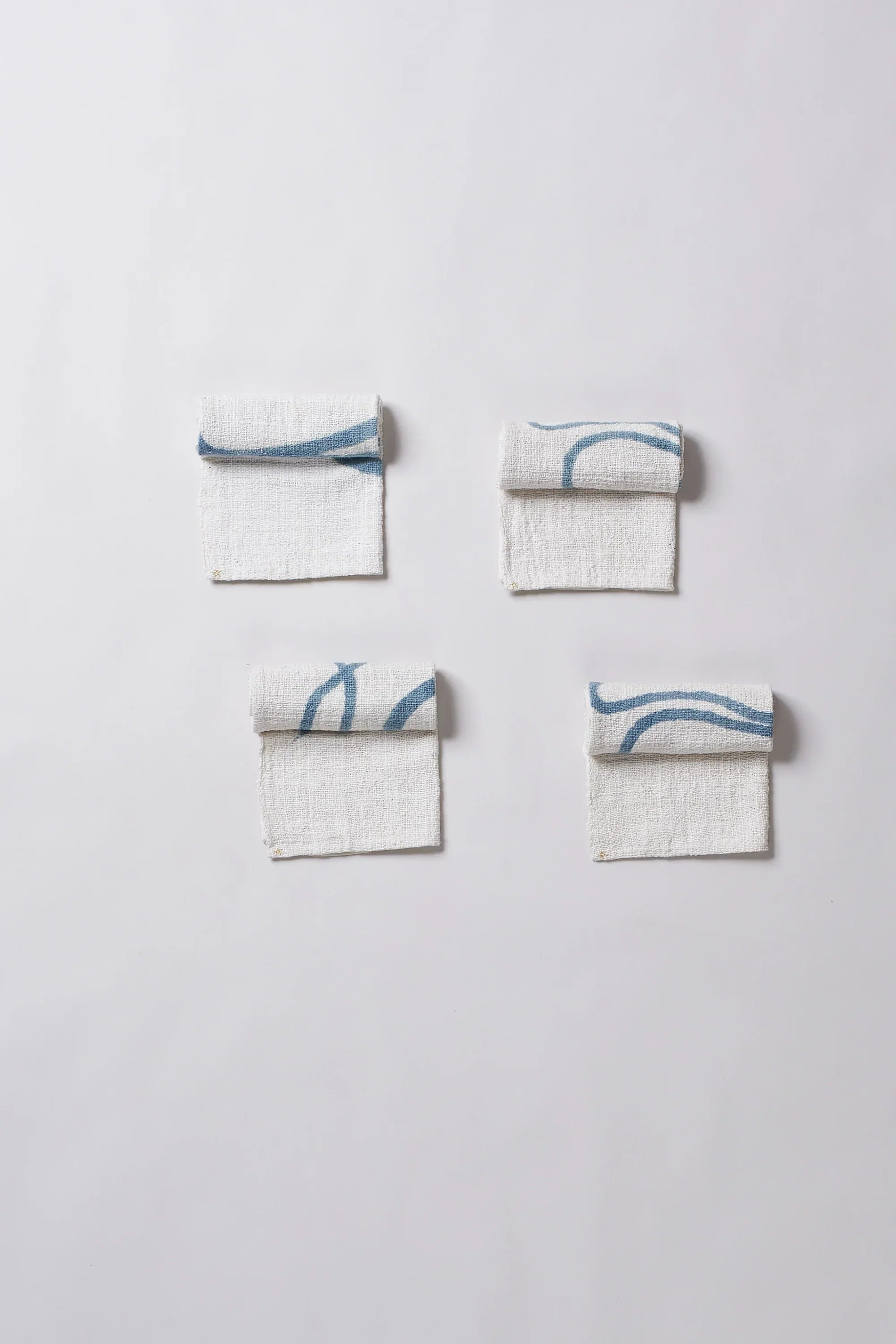 Ecru cotton towel roll on a light grey background