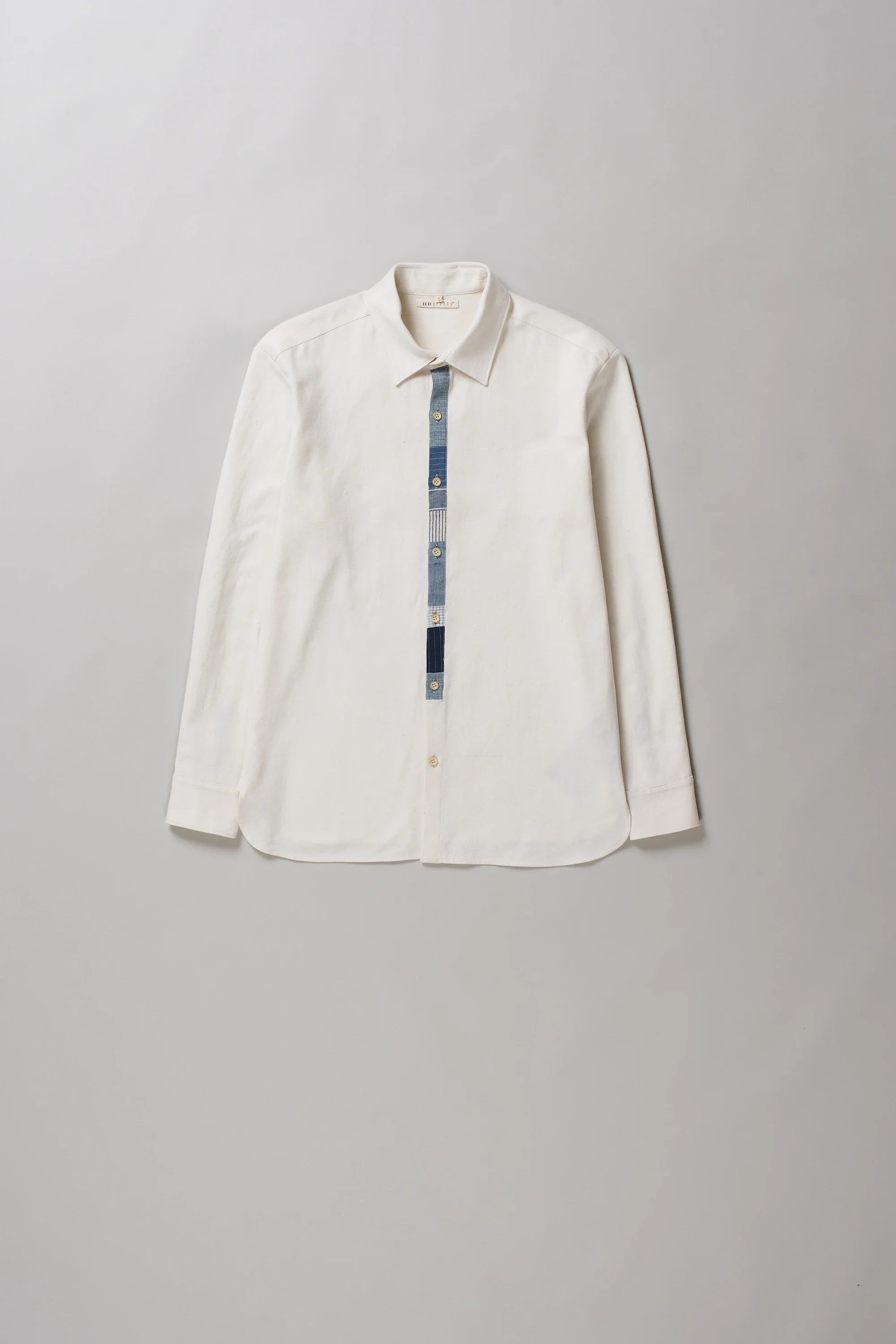 An off-white long-sleeve button-up shirt in ecru