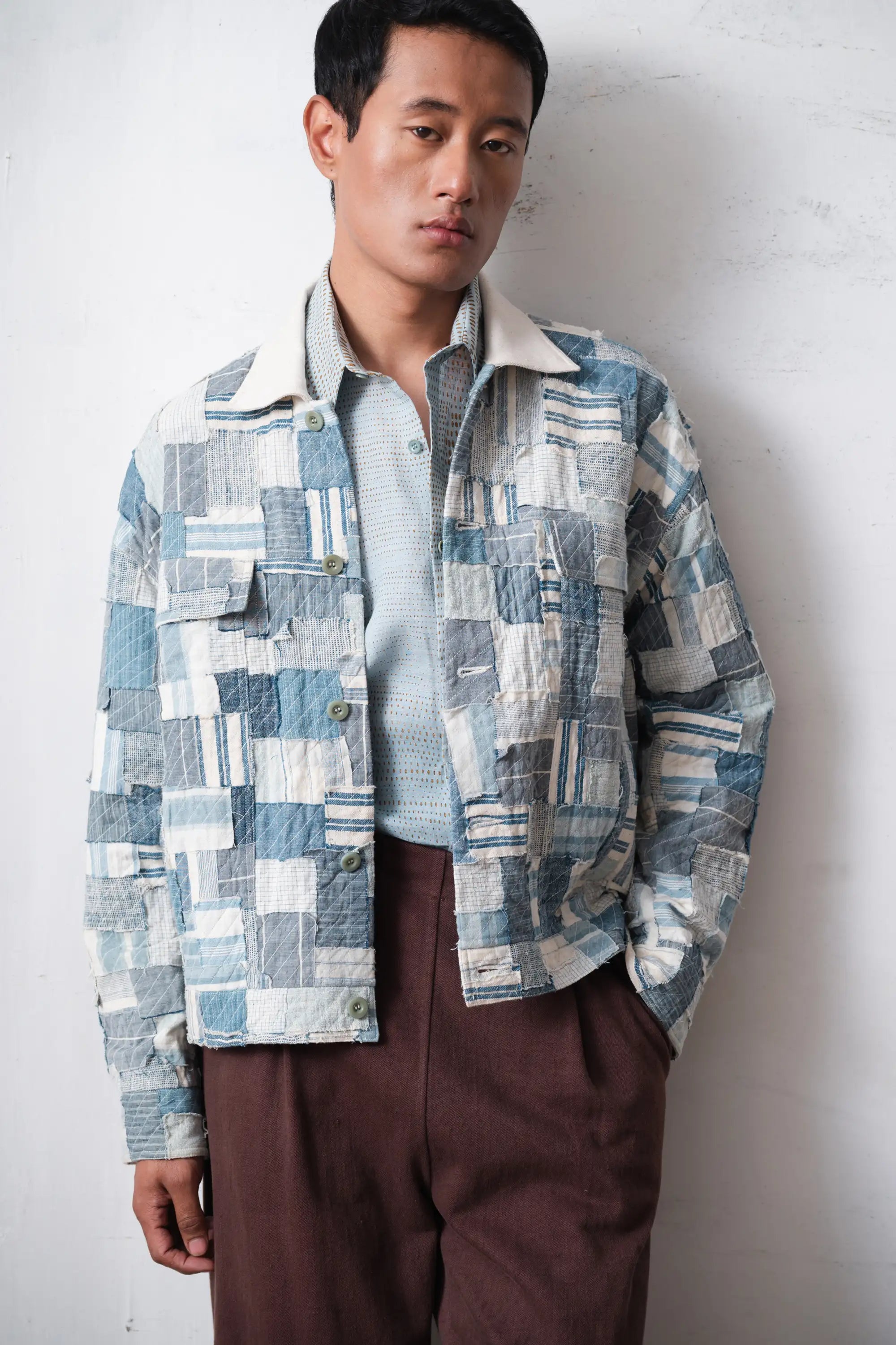 A man wearing indigo patchwork jacket