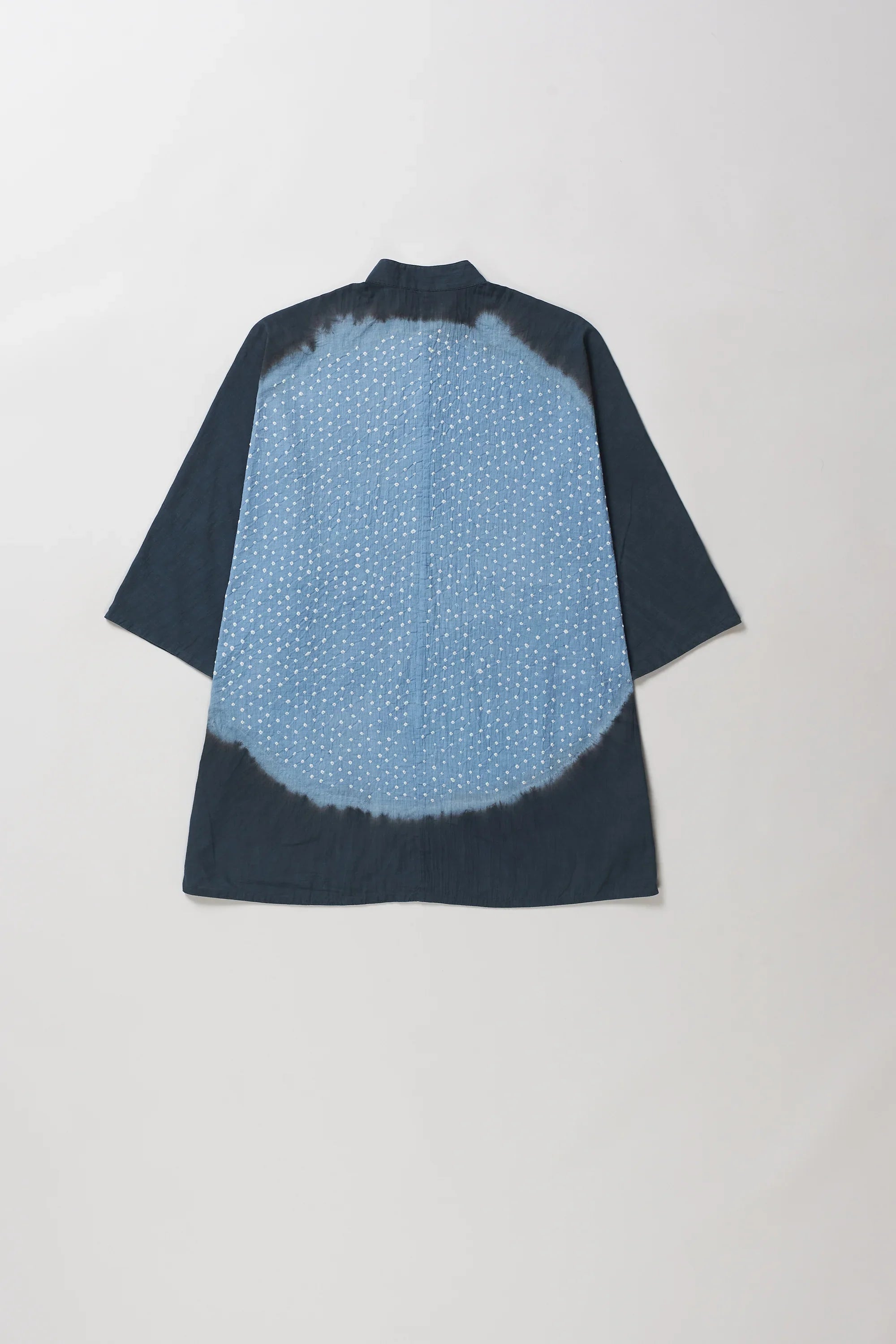 Back shot of midnight indigo and tie-dye short-sleeve shirt shown from the back, featuring a solid dark blue border and a lighter blue center with a white dotted pattern.